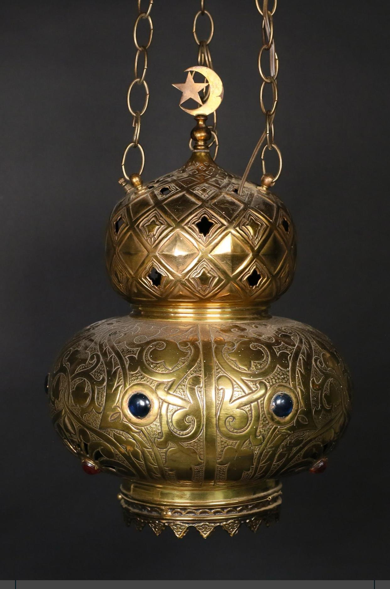 Moorish style hanging lamp. Three chains supporting brass lamp set with colored glass faux gemstones and topped with moon and star finial. 
Beautiful light emitted from the pierced brass double gourd form pendant and the jewel form inset glass.
