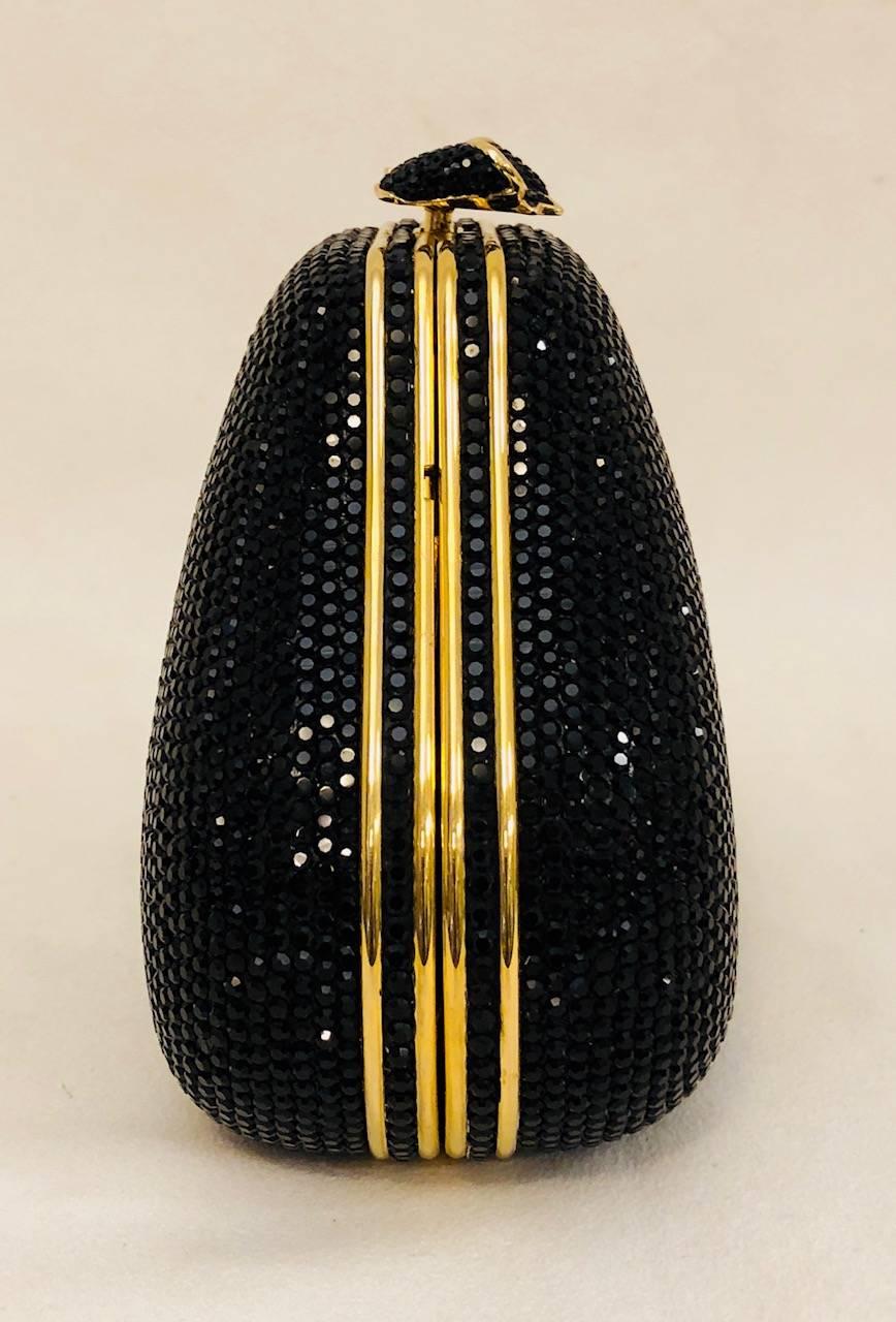 Glimmering Judith Leiber black Swarovski crystal-embellished mini minaudière with gold-tone hardware.  Includes single drop-in snake-chain shoulder strap and the inside is lined in shimmering metallic gold leather.  For closure this minaudiere has a