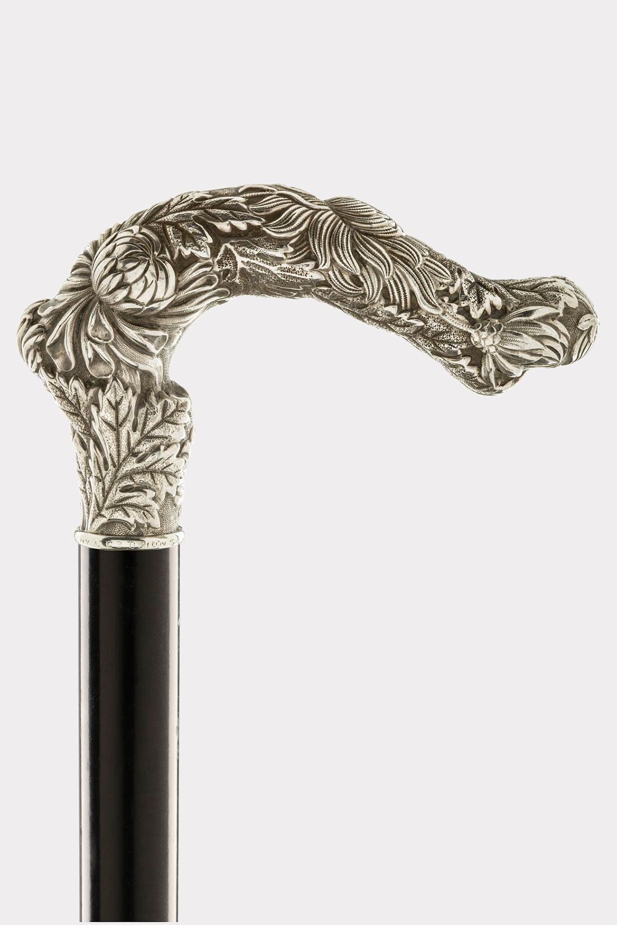 Walking Stick: A jeweled cane, a curved handle in sterling silver, 925/1000, embossed and chiselled, featuring the Tiffany Chrysanthemum floral motif. The design is distinguished by the density of the flowers and foliage. Chrysanthemum represents
