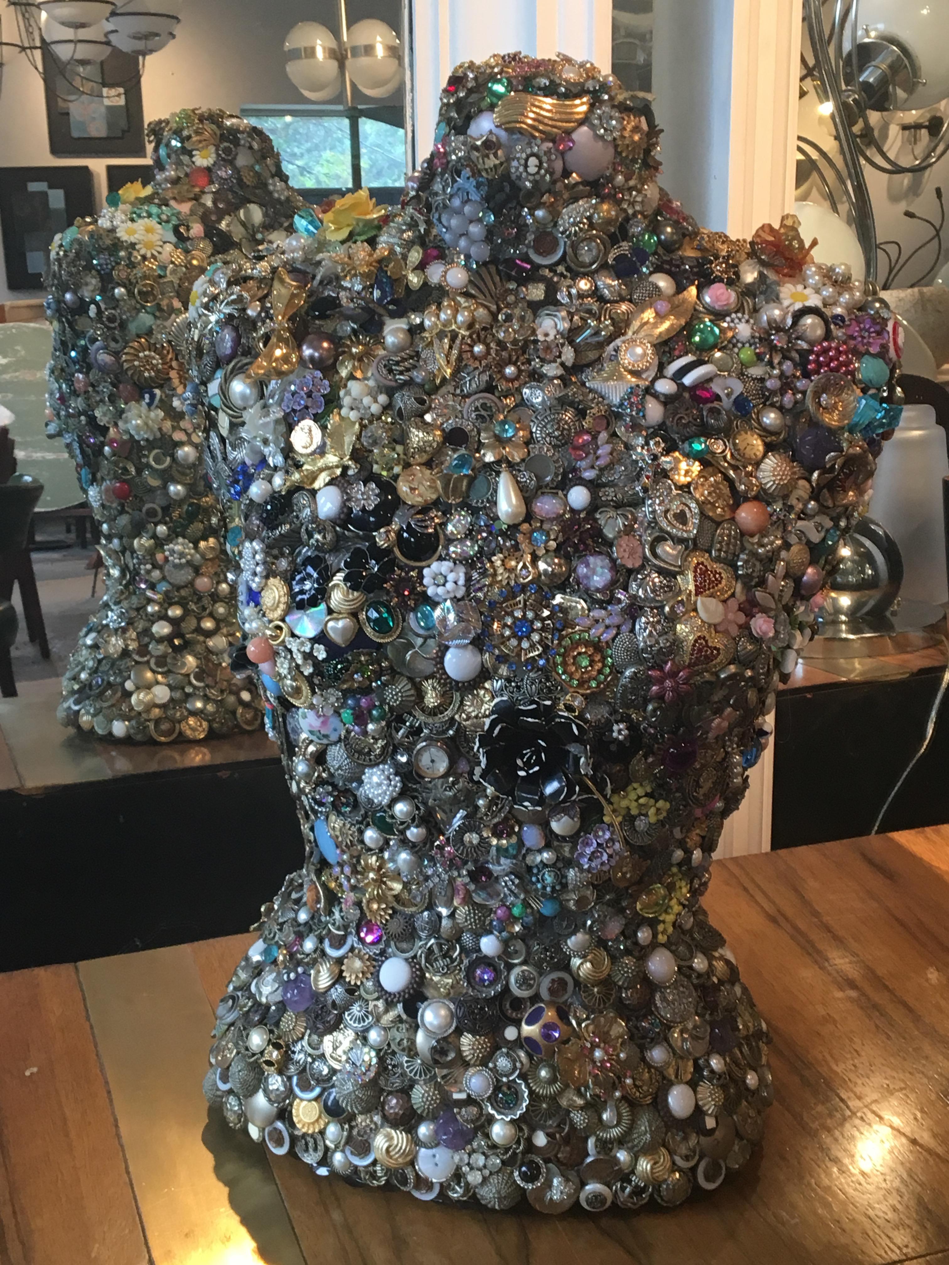 Vintage dress form entirely covered in vintage jewelry, timepieces, and buttons.