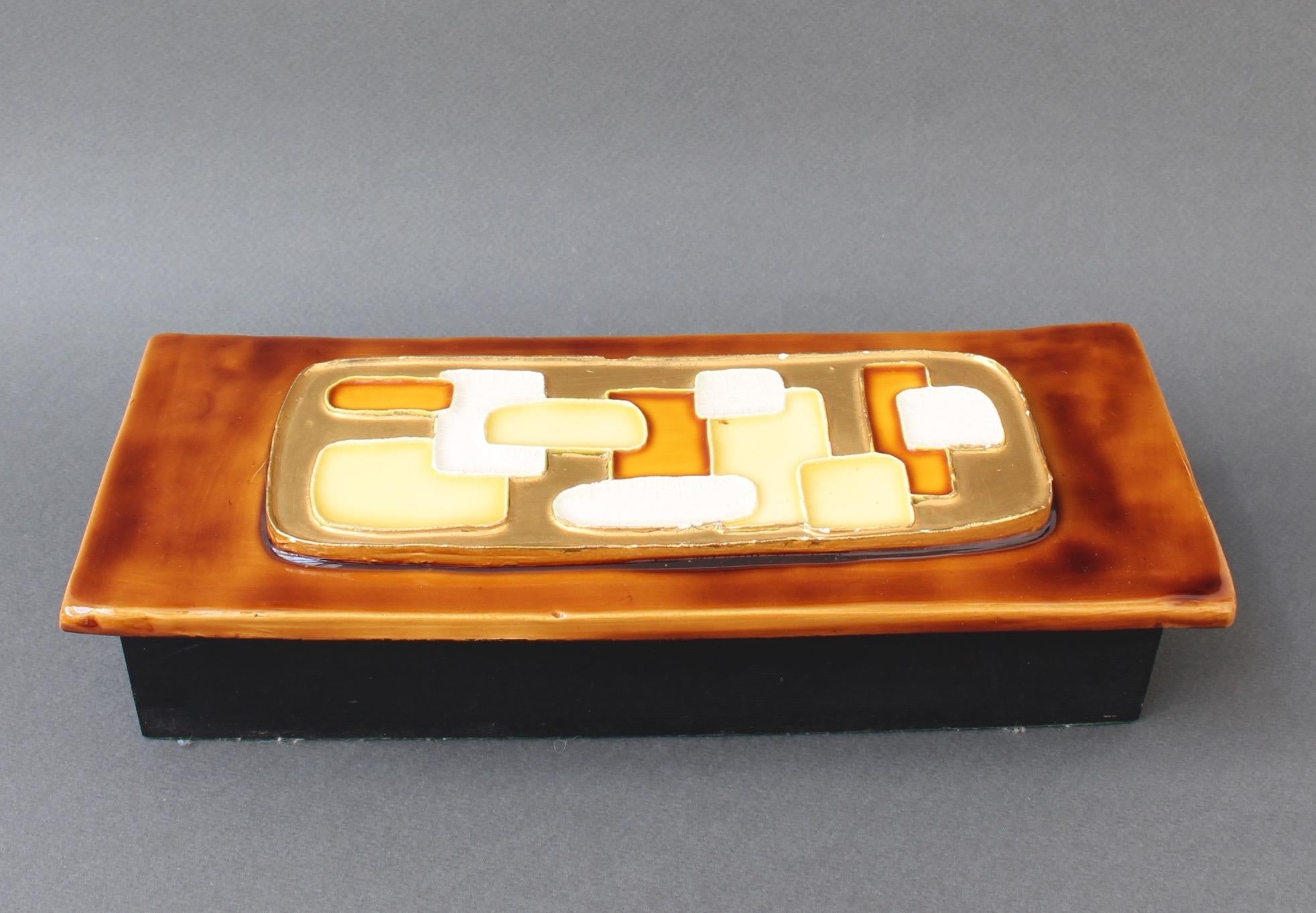 Jewellery box with decorative ceramic lid by François Lembo (circa 1960s). Mid-Century Modern style raised abstract motif with yellow, white and caramel coloured geometric shapes imbedded in gold crackle (with small evident chip) over a glossy