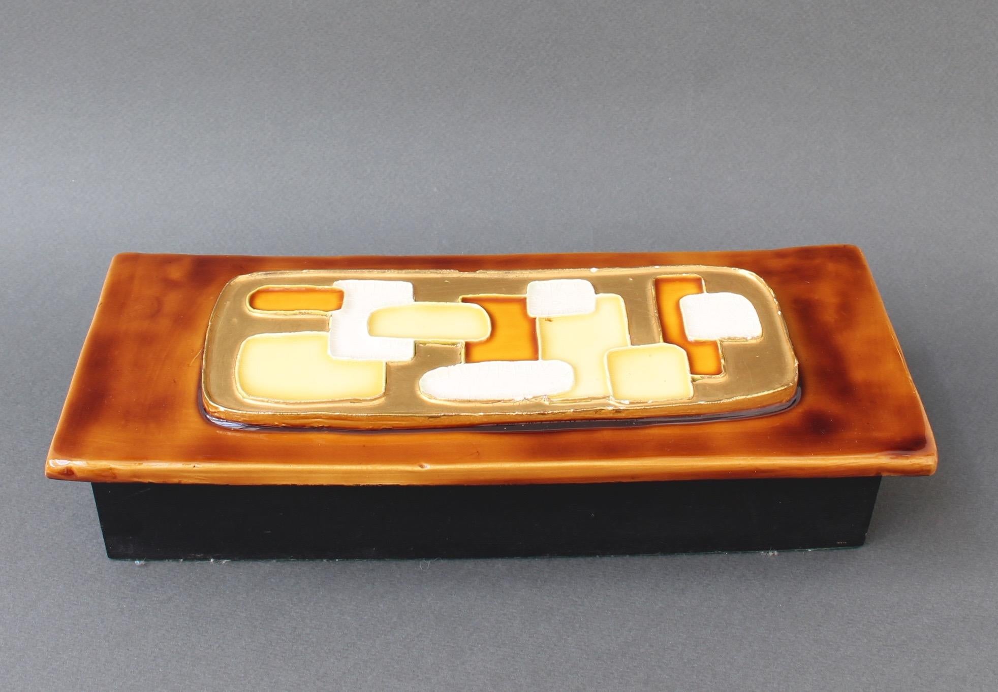 Jewellery box with decorative ceramic lid by Mithé Espelt (circa 1960s). Mid-century modern style raised abstract motif with yellow, white and caramel coloured geometric shapes imbedded in gold crackle (with small evident chip) over a glossy caramel