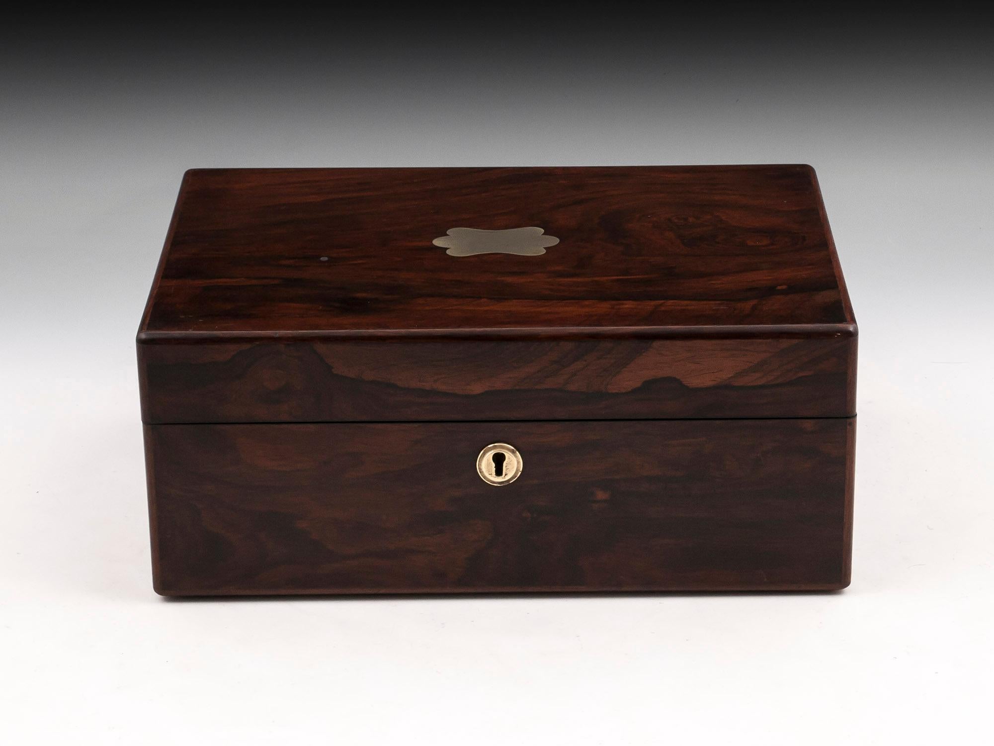 Antique Jewelry Box veneered in beautiful figured mahogany with brass escutcheon and vacant initial plate.

The interior is lined in vibrant red velvet and silk paper. It contains a removable jewelry tray with seven padded compartments of which two