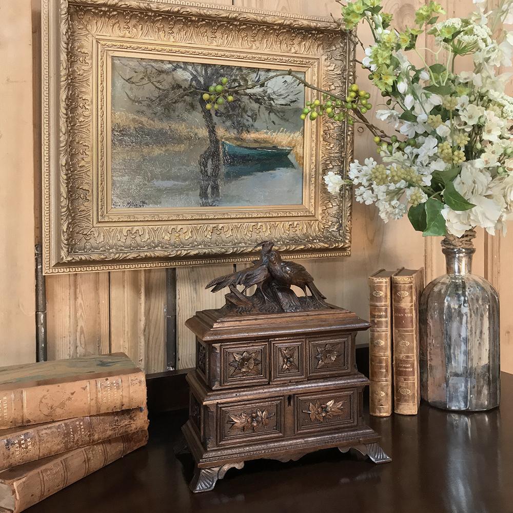 19th century French hand carved jewelry box features two lovebirds sculpted on top, with floral and foliate panels framed in molding all around the facade below, set upon carved feet. Center sections swing out and top opens to reveal a blue velvet