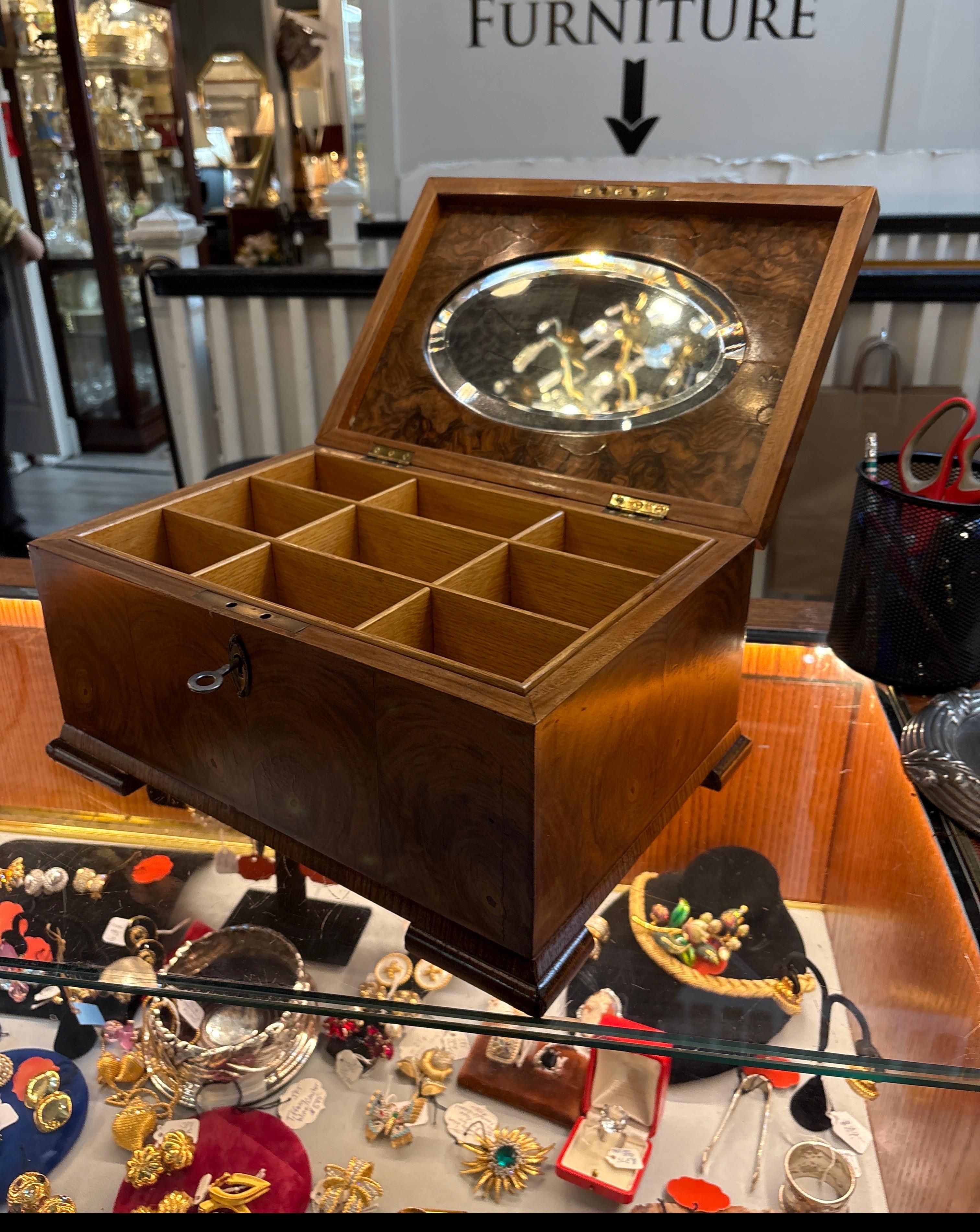 Une superbe boîte à bijoux en ronce de noyer.  La surface est polie, avec une serrure et une clé d'origine et un couvercle à charnière.  L'intérieur s'ouvre pour révéler un miroir ovale biseauté avec un plateau à compartiments sectionnés qui se