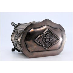 Jewelry box, in embossed silver and resting on four tall feet and a hinged lid