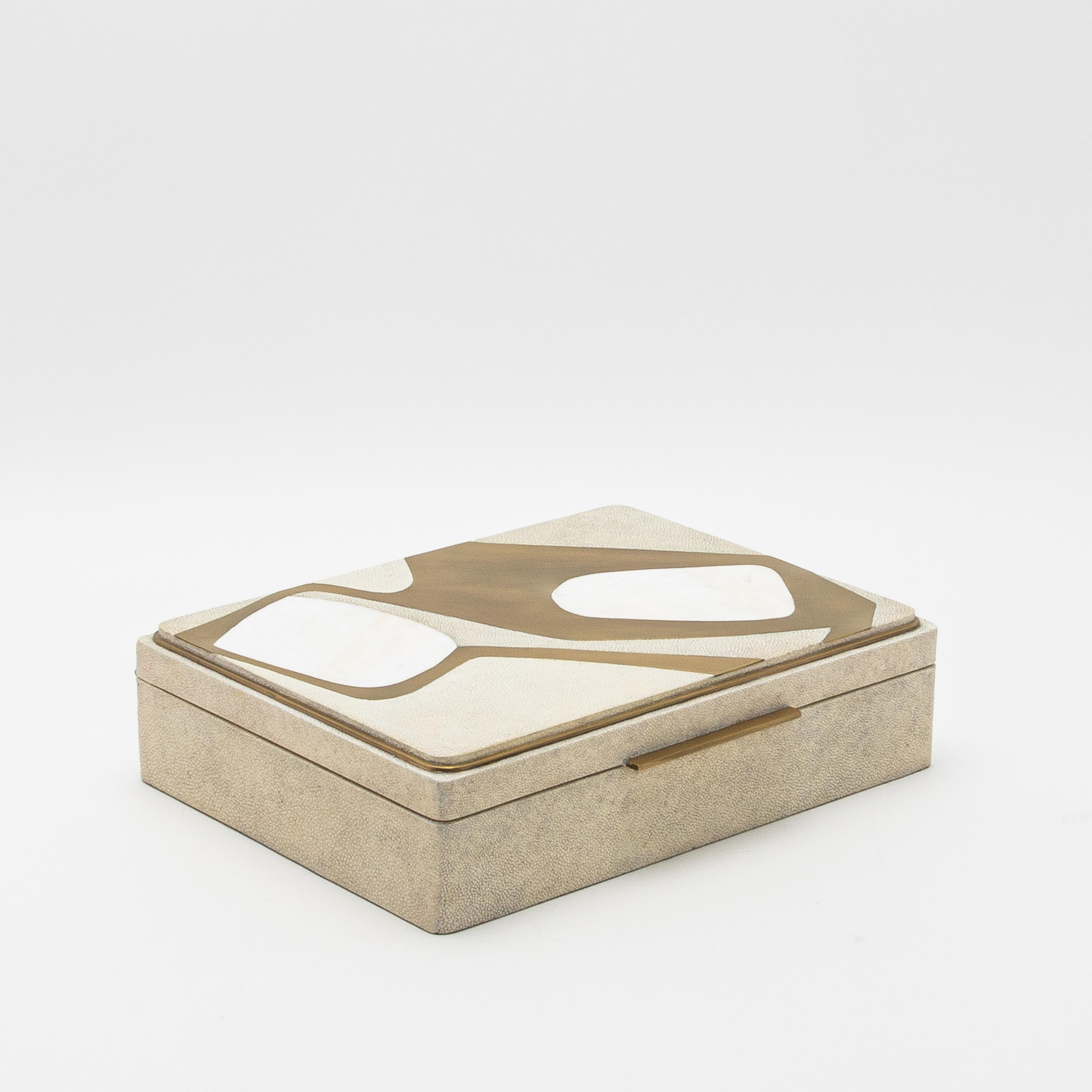 This jewelry box by R&Y Augousti is a luxurious fusion of artistry and craftsmanship, wrapped in sophisticated shagreen. The meticulously handcrafted Cosmos pattern blends mother-of-pearl and brass inlays, creating a fluid, organic design on the