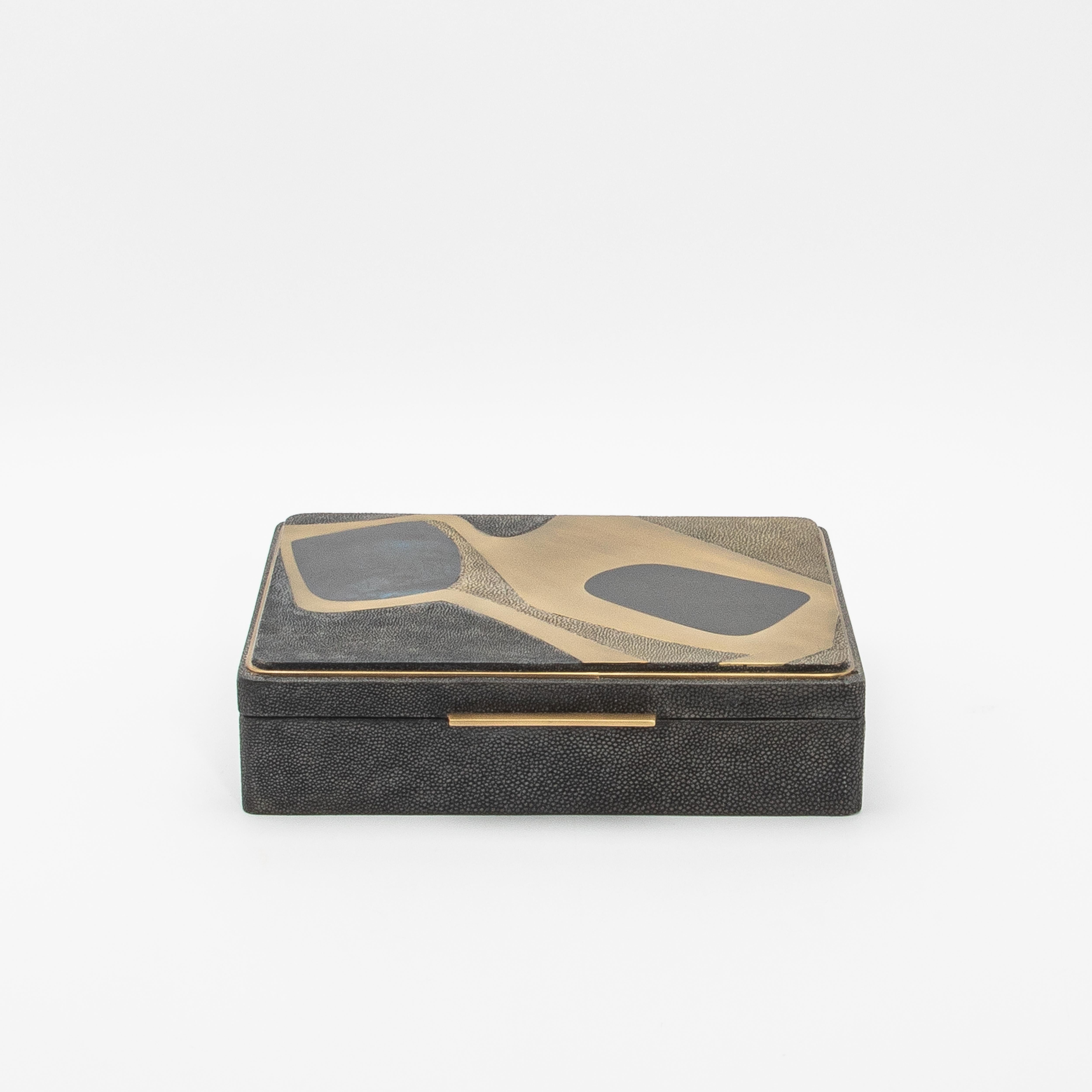 This jewelry box by R&Y Augousti is a luxurious fusion of artistry and craftsmanship, wrapped in sophisticated shagreen. The meticulously handcrafted Cosmos pattern blends mother-of-pearl and brass inlays, creating a fluid, organic design on the