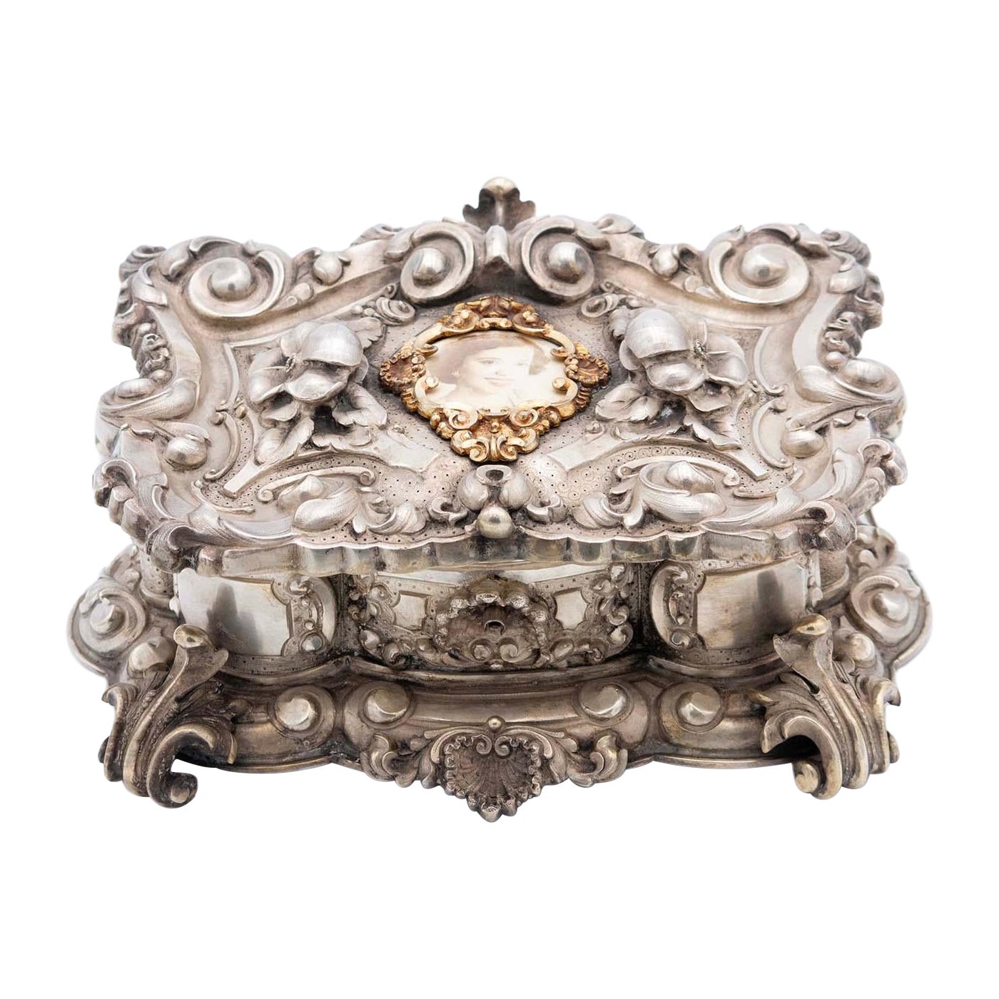 Jewelry box, in silver with deep reliefs of flowers and a portrait in the center For Sale