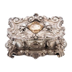 Jewelry box, in silver with deep reliefs of flowers and a portrait in the center Jewelry box, in silver with deep reliefs of flowers and a portrait in the center