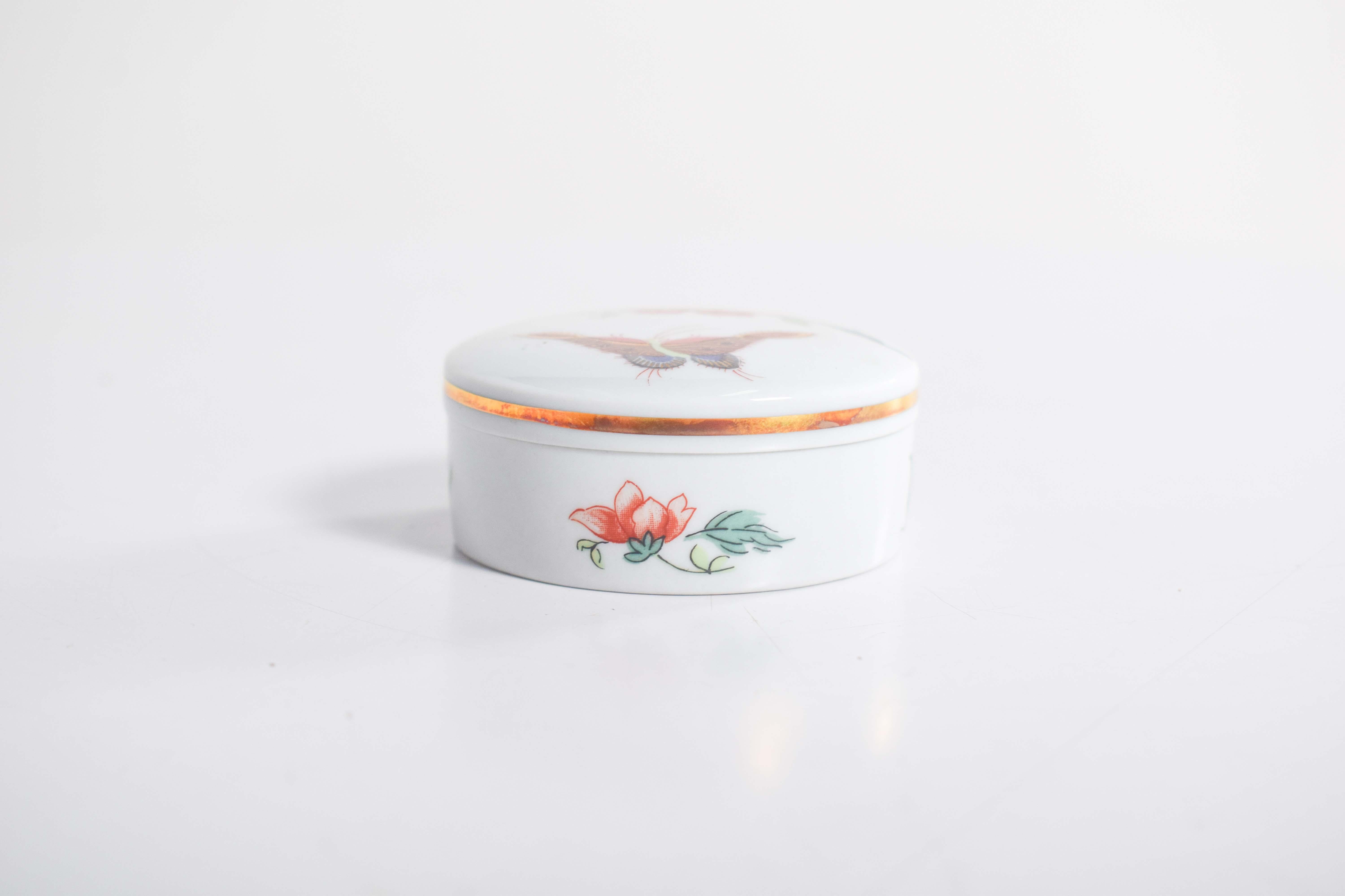 A jewelry box made from Vista Alegre porcelain is a beautiful and elegant piece, known for its high-quality craftsmanship and refined design. The porcelain itself has a smooth, glossy finish that gleams with a delicate, almost ethereal quality. The