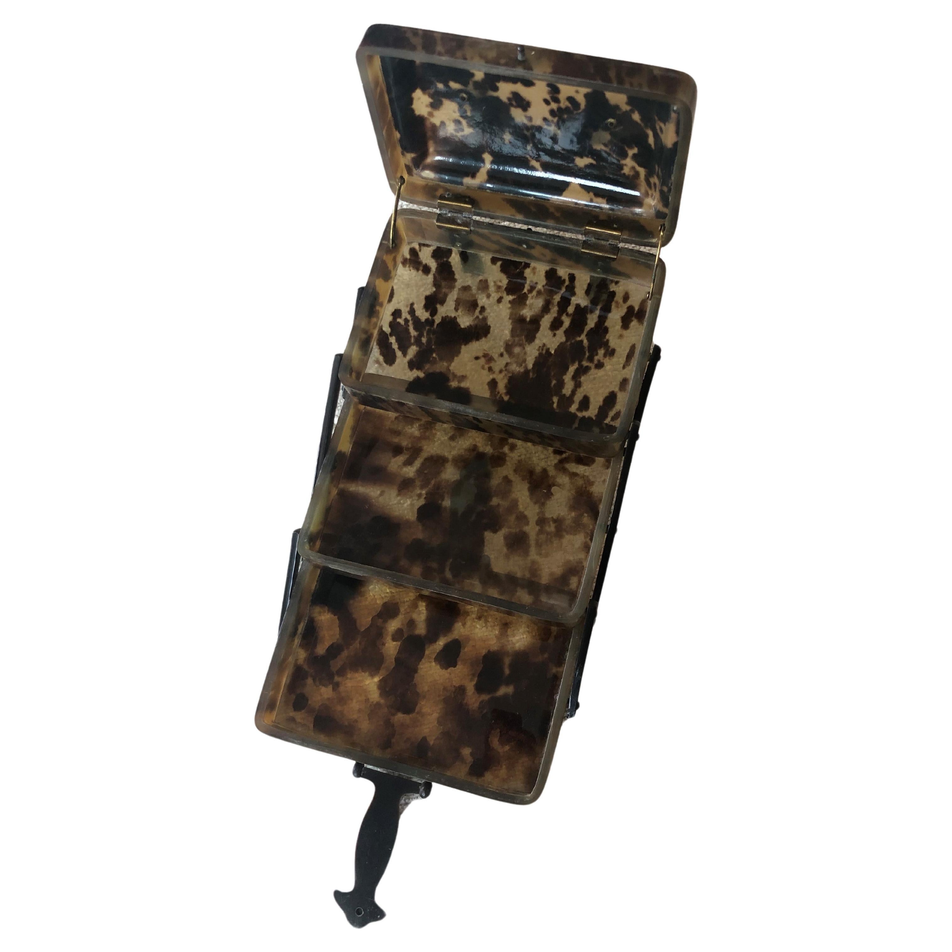 This is a multi layered folding faux tortoise jewelry box with vertical clasps. 
It’s originally from London, and is meant for compartmentalizing jewelry, probably rings for easy access. It has a lovely patina.