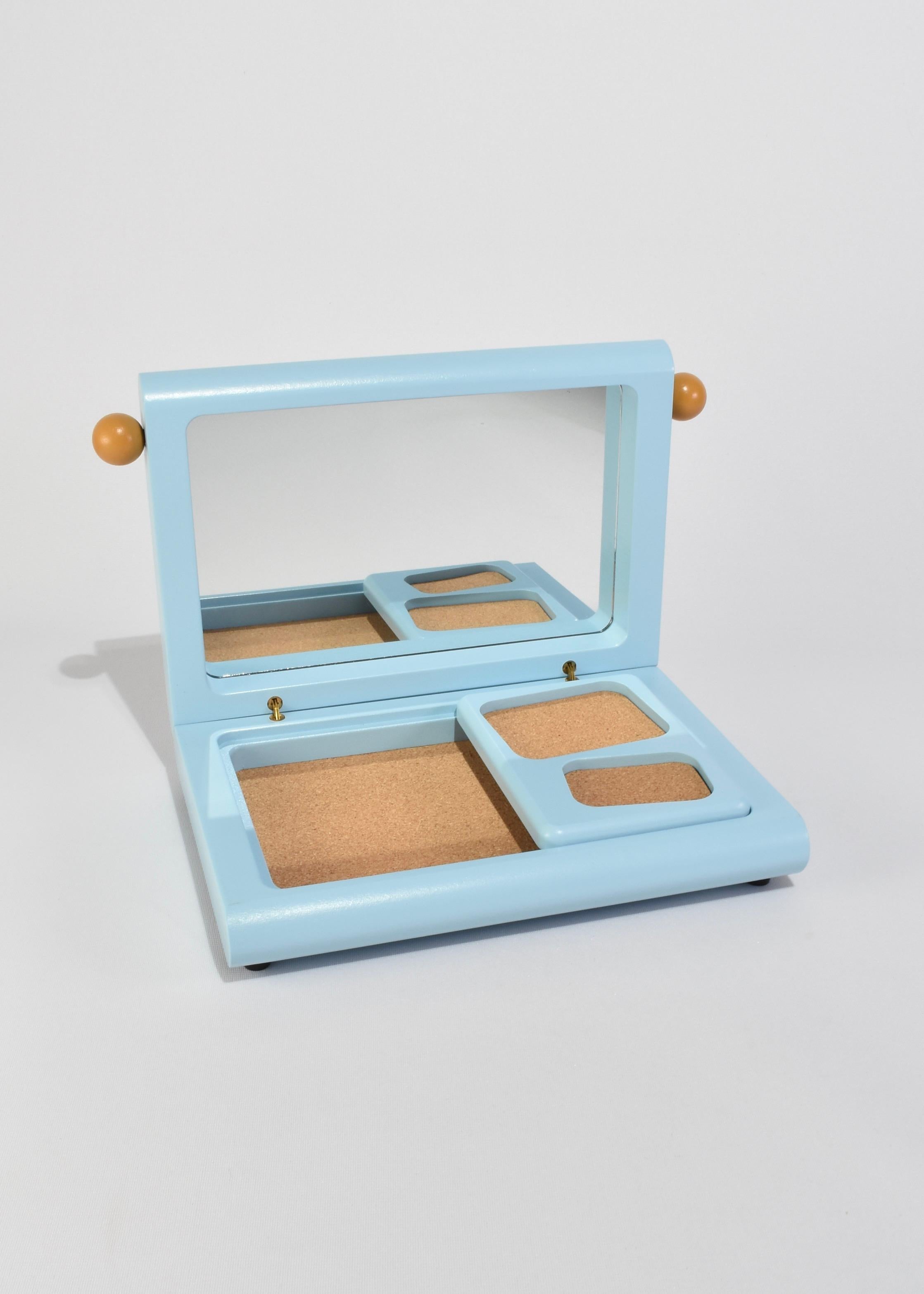 A jewelry box in bright blue with brown knobs—a balance of restraint and play. Designed by Sarah Burns for Areaware, its curved form houses a cork-lined compartment, removable tray, and inset mirror. Thoughtful in design and timeless in appeal, it