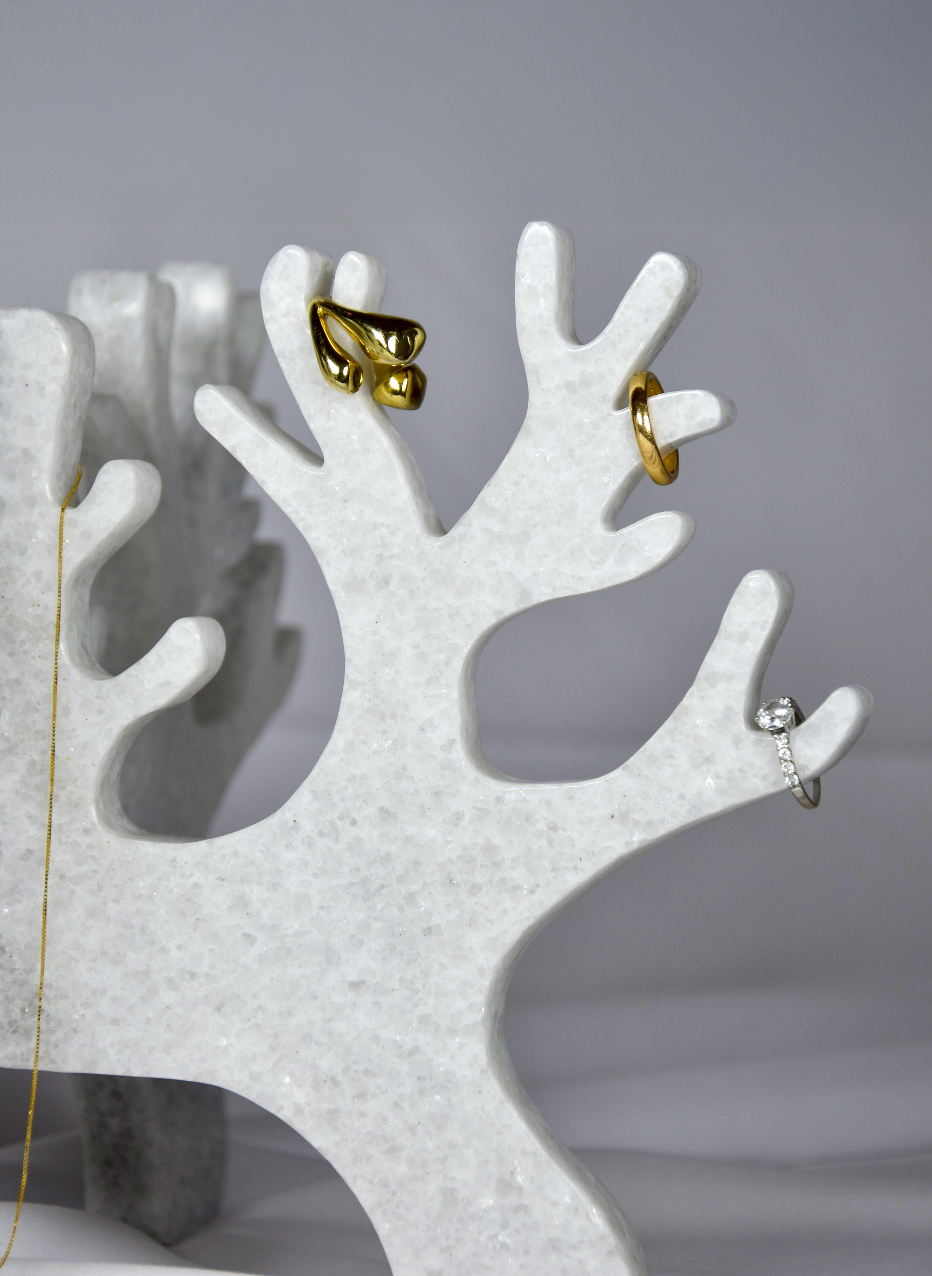 Jewelry est une boîte à bijoux sculpturale en marbre blanc Cristallina®, inspirée par la forme ramifiée du corail. Les branches sinueuses créent des supports élégants et fonctionnels pour les bracelets, les bagues et les colliers, transformant la