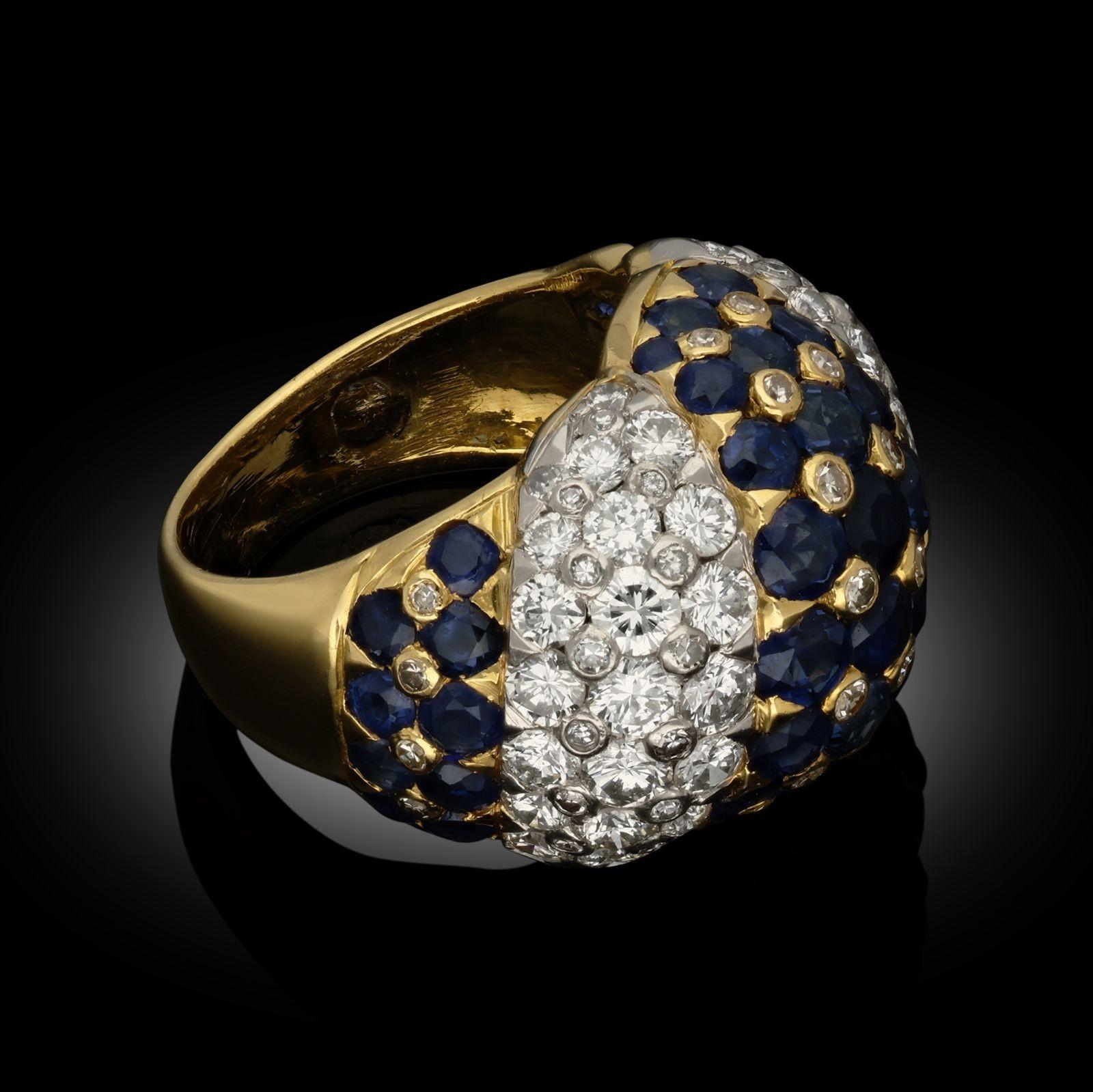 A vintage 18ct gold, diamond and sapphire dress ring by Tiffany & Co. circa 1970s, the domed shape bombé ring pavé set throughout with round faceted diamonds and sapphires in a diagonal banded stripe, the sapphires set in yellow gold and the