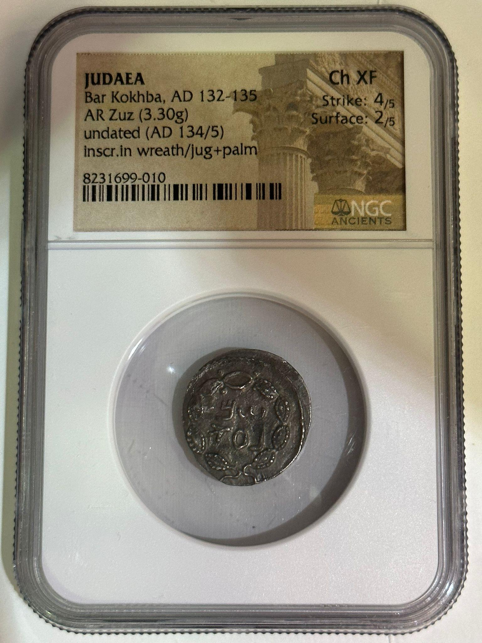 This silver zuz coin, weighing 3.30 grams, was minted during the Bar Kokhba Revolt, a Jewish uprising against Roman rule in Judaea from AD 132 to 135. Undated but attributed to the years AD 134/135, this piece is a powerful symbol of resistance and