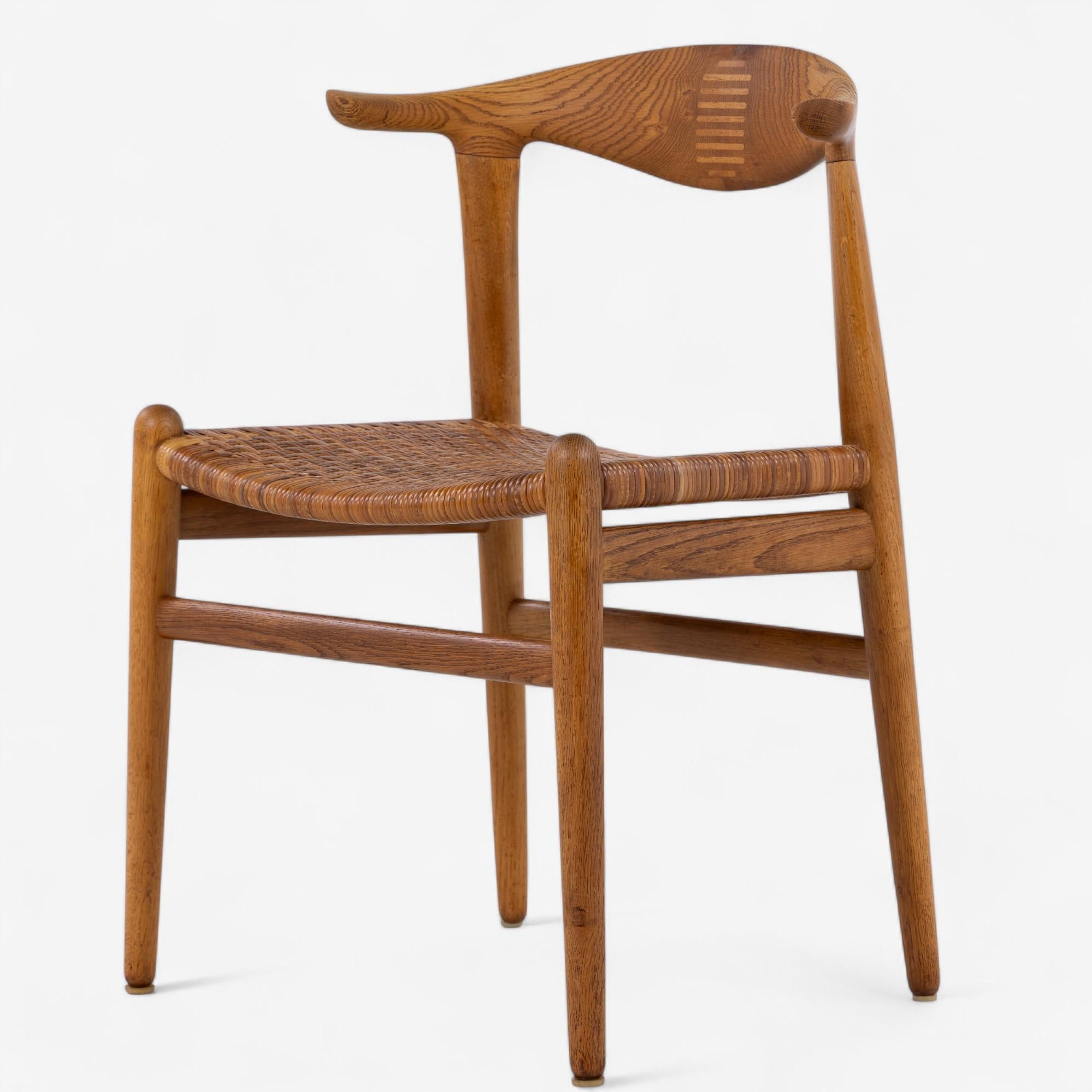 JH 505 - Sedia 'Cow Horn' in rovere patinato con seduta in vimini originale. Disegnata nel 1952 da Hans J. Wegner, prodotta da Hansen.