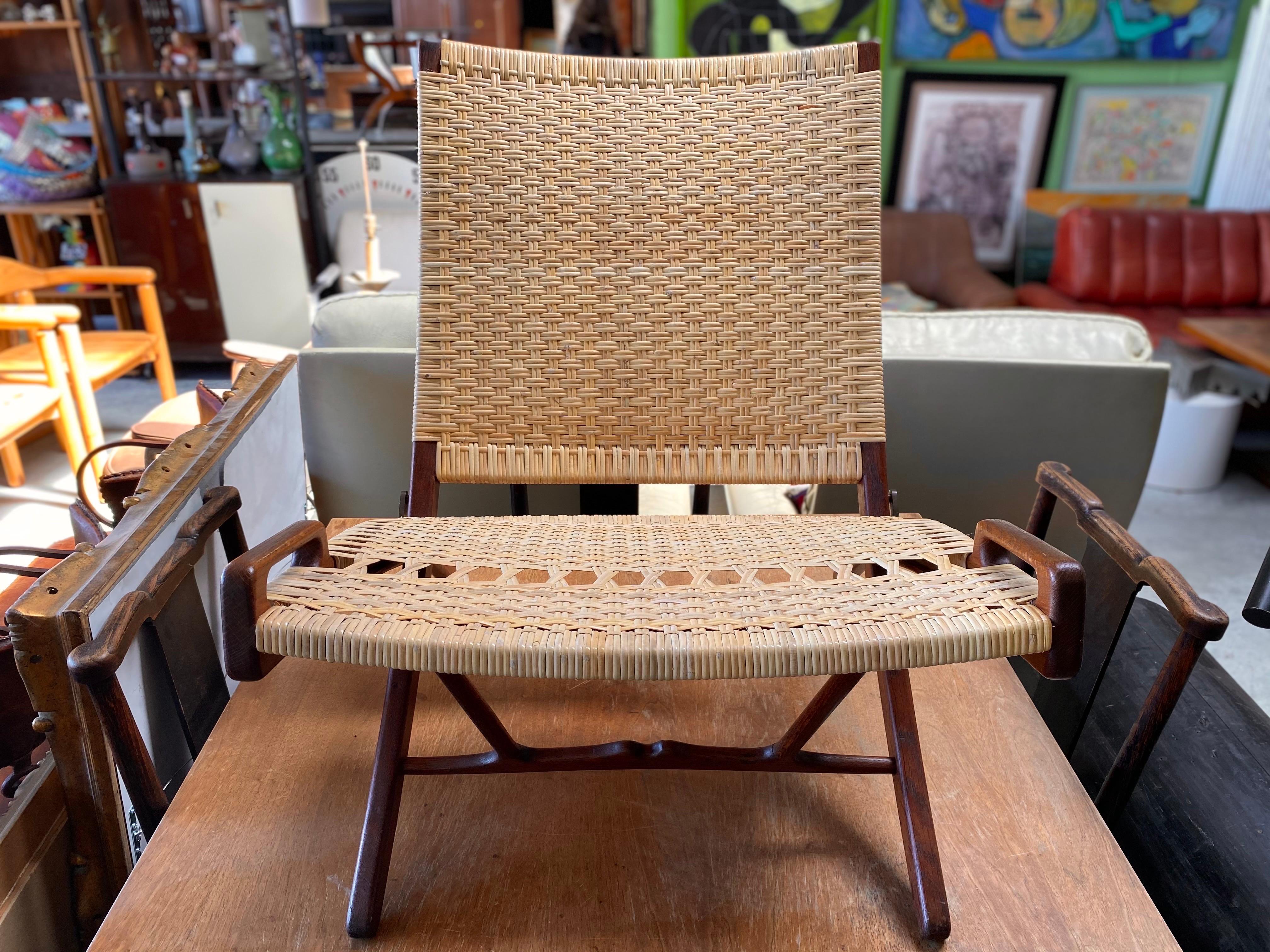 Stunning mid-century modern Hans J. Wegner iconic folding lounge chair, circa 1950s. The model 512 chair was produced by cabinetmaker Johannes Hansen in Copenhagen The rattan has been redone and this unique design piece is in great vintage condition.