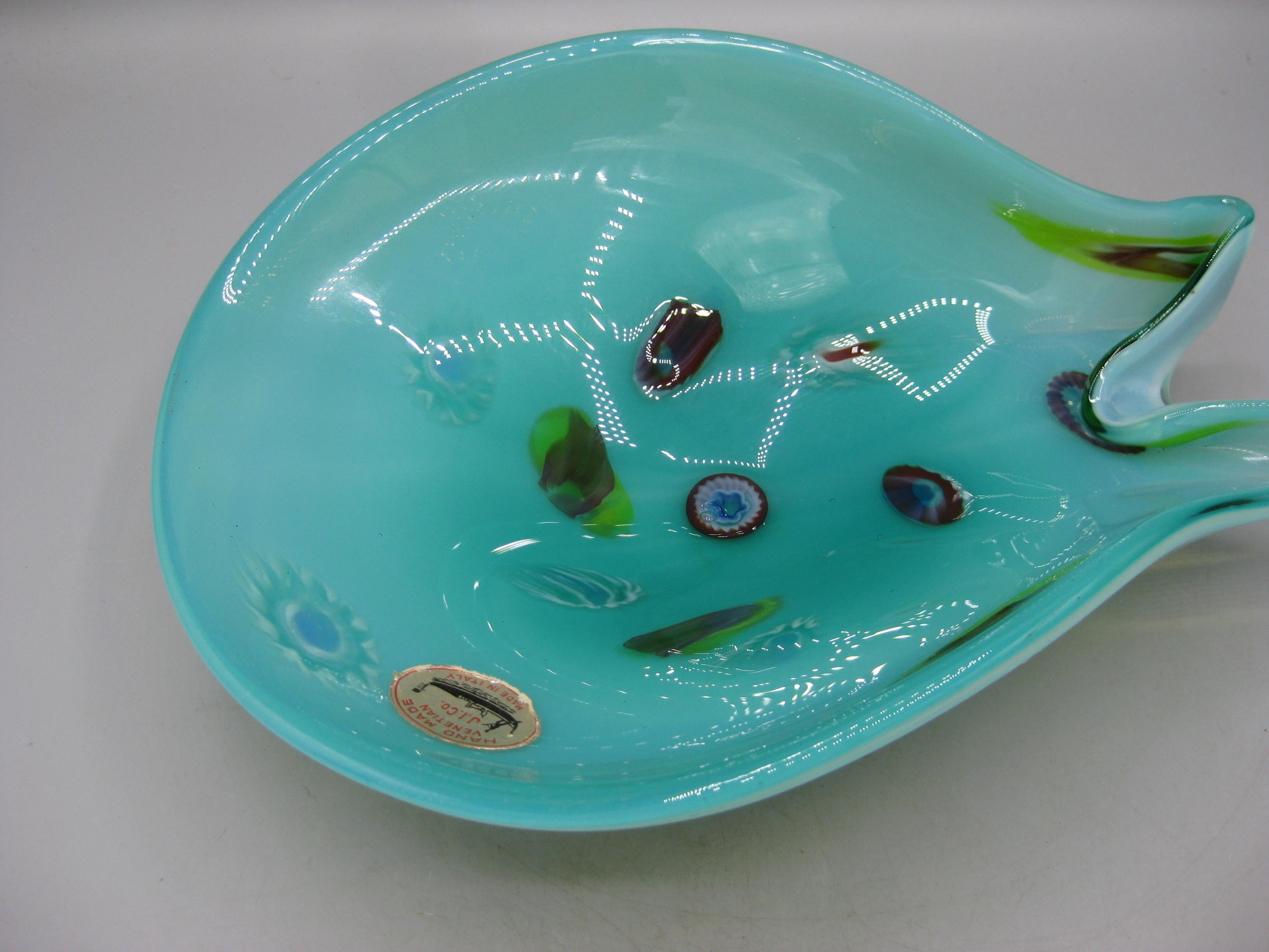 Beautiful blue abstract shaped Murano art glass bowl/dish designed by Fratelli Toso for Venetian J.I. Co glass, circa 1960s. Wonderful color and shape. Has several millefiori shapes in the glass. Has the original foil label on the inner surface.