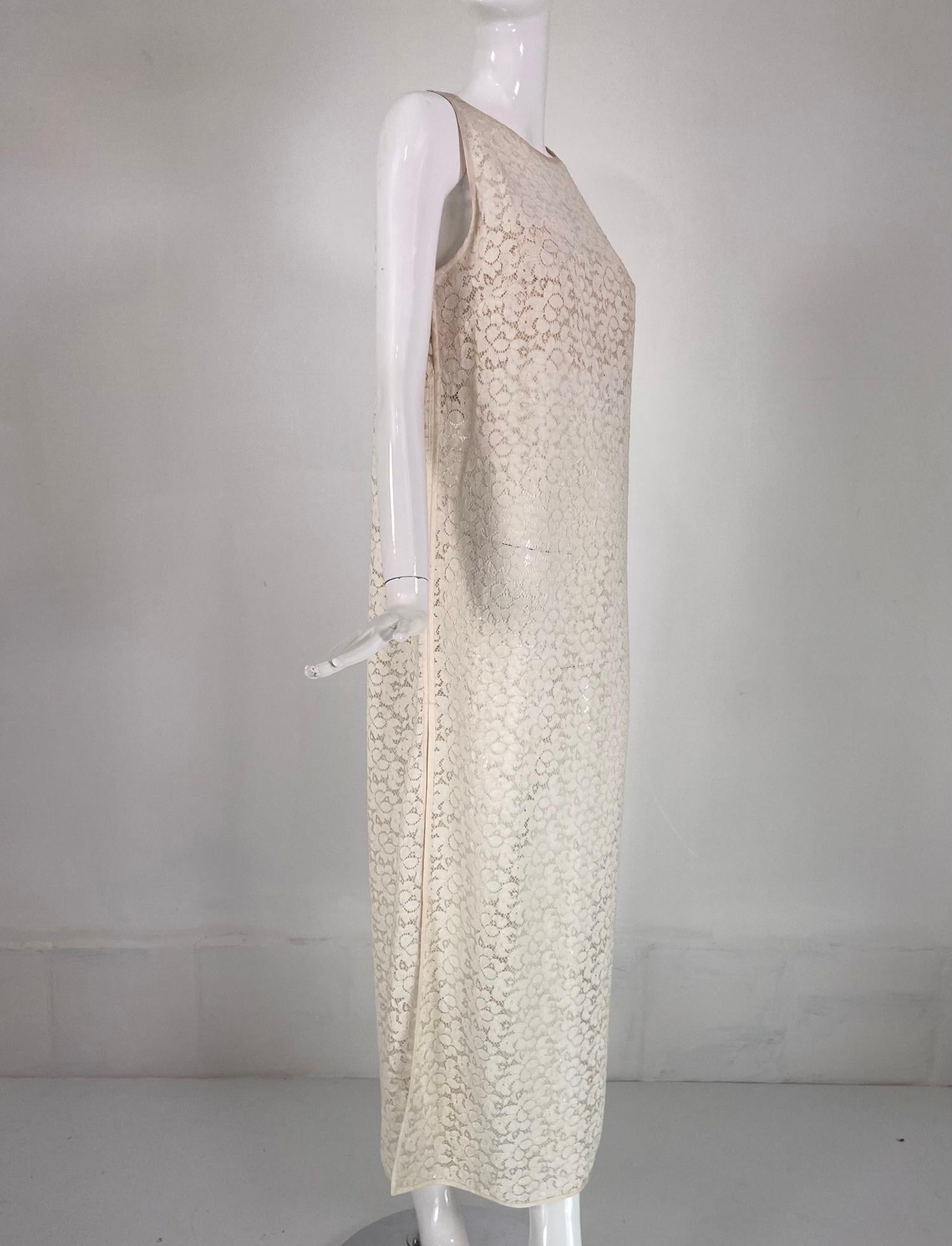 Jiki Monte Carlo Creations off white lace maxi shift dress. Sleeveless, jewel neck maxi dress of off white textured lace, trimmed in off white satin. Slip on dress closes at the shoulders with self button and loops, it also closes at each under arm