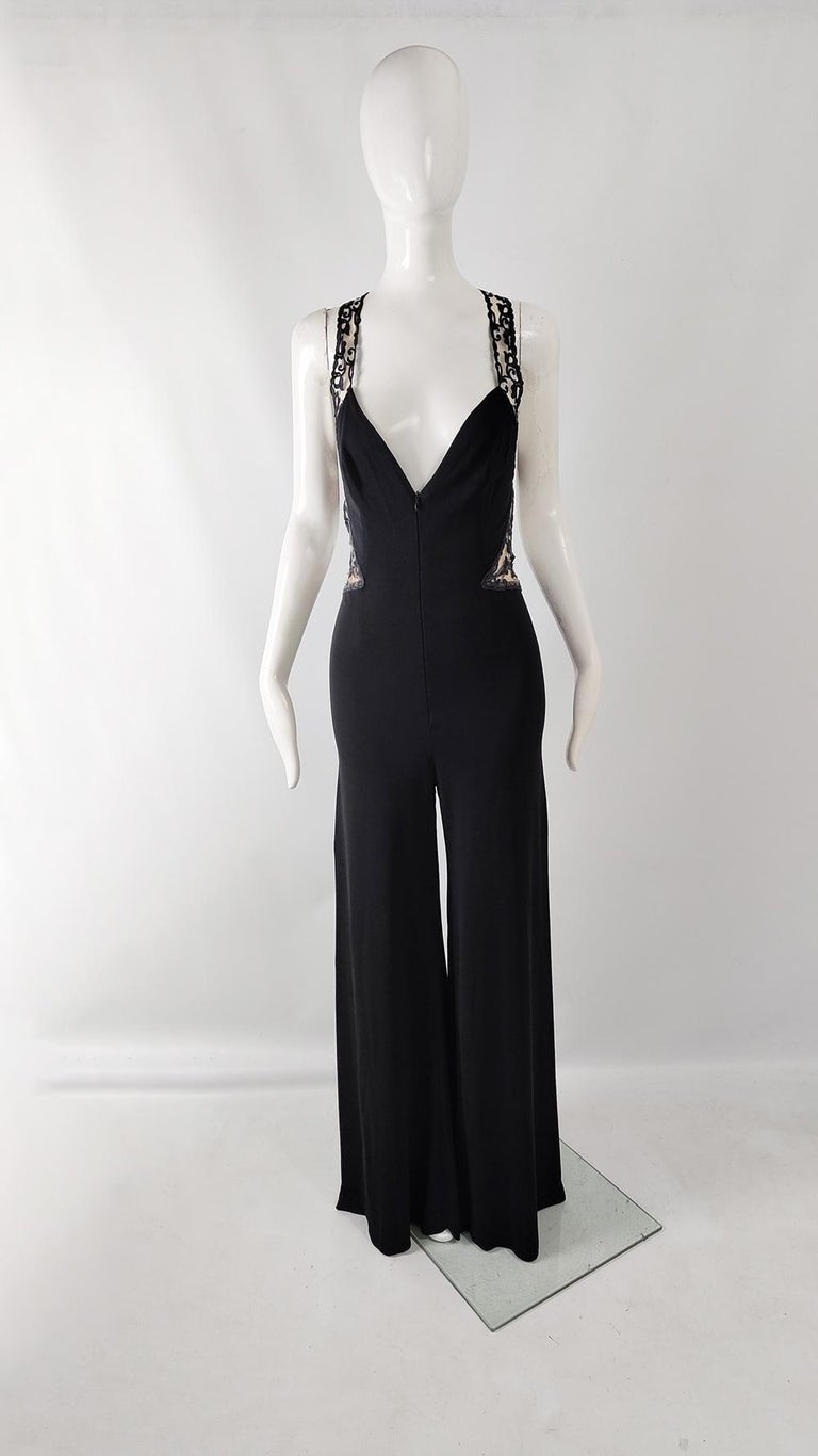 An incredibly sexy vintage womens evening jumpsuit from the 90s by luxury Monaco based fashion house, Jiki of Monte Carlo. In a black viscose jersey that gives amazing drape with cut outs with a sheer nude lace trim and a scandalously plunging back