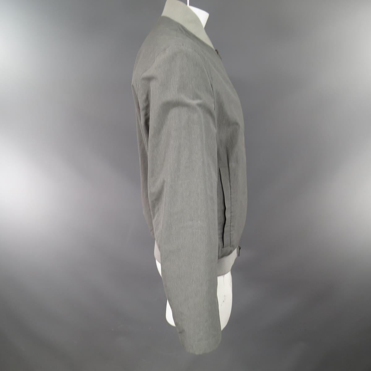 JIL SANDER jacket comes in a silver cotton silk blend featuring a silver ribbed neck, waist band, double zipper front, and double slit pockets. Minor discoloration throughout. Made in Italy.

Good Pre-Owned Condition.
Marked: