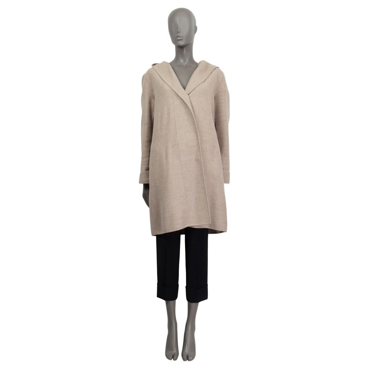 100% authentic Jil Sander long sleeve between-seasons coat in sand fleece wool (90%) and angora (10%). Features a hood and two slit pockets on the front. Opens with one brown button on the front. Pockets lined in beige silk (100%). Has been worn and