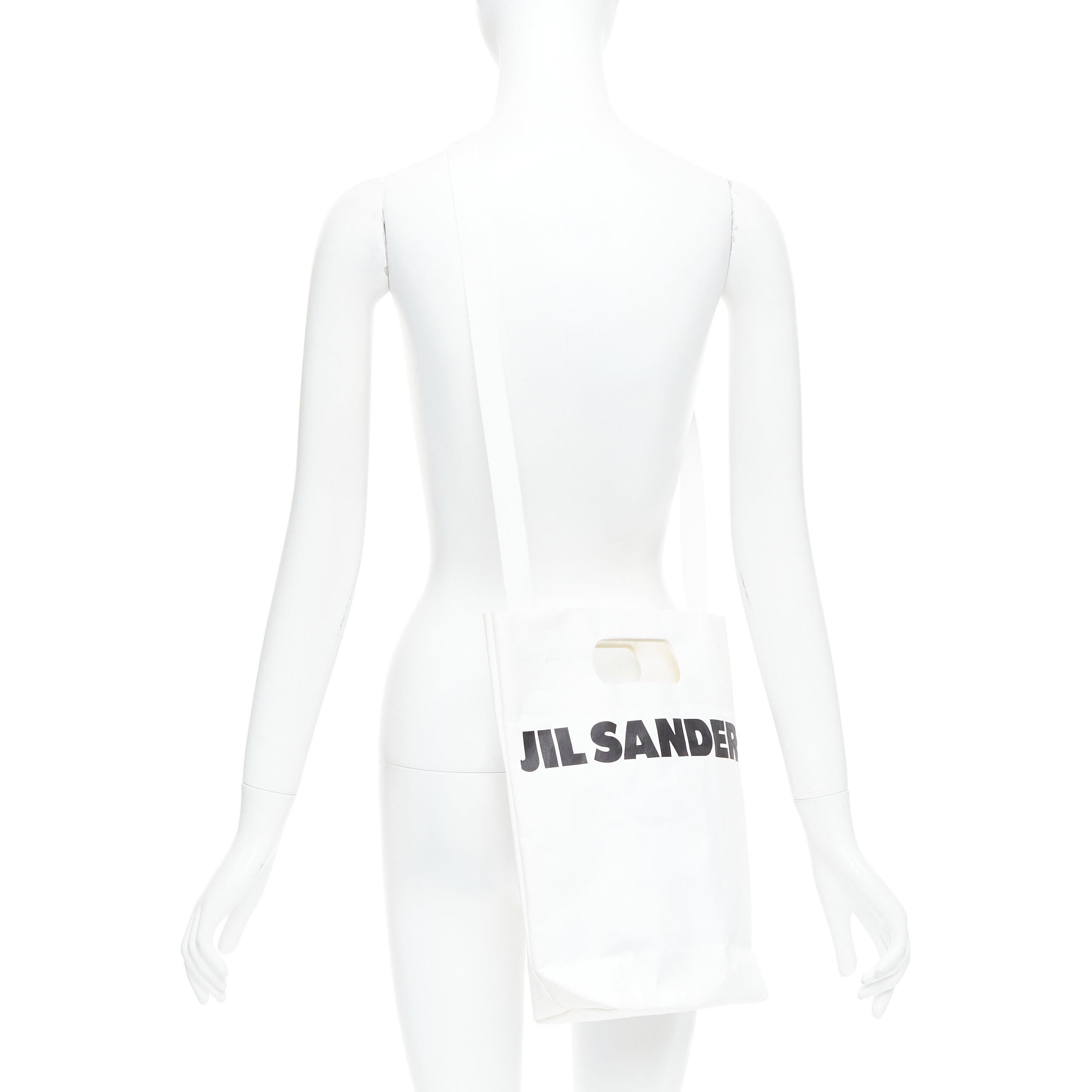 JIL SANDER cream black laminated paper logo crossbody tote bag
Reference: SNKO/A00510
Brand: Jil Sander
Material: Paper, Fabric
Color: Cream, Black
Pattern: Solid
Lining: White 
Extra Details: Convertible with strap.

CONDITION:
Condition: Fair,