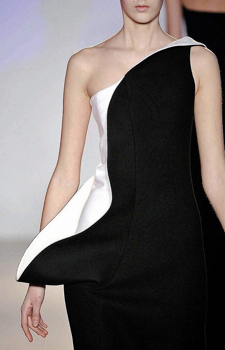 Stunning Jil Sander in a black and white palette featuring a one shoulder sculptural silhouette. Boasts a sculpted section from the shoulder to hip that stylishly hugs the side of upper body.  Fully lined with a side zip closure.  A timeless classic