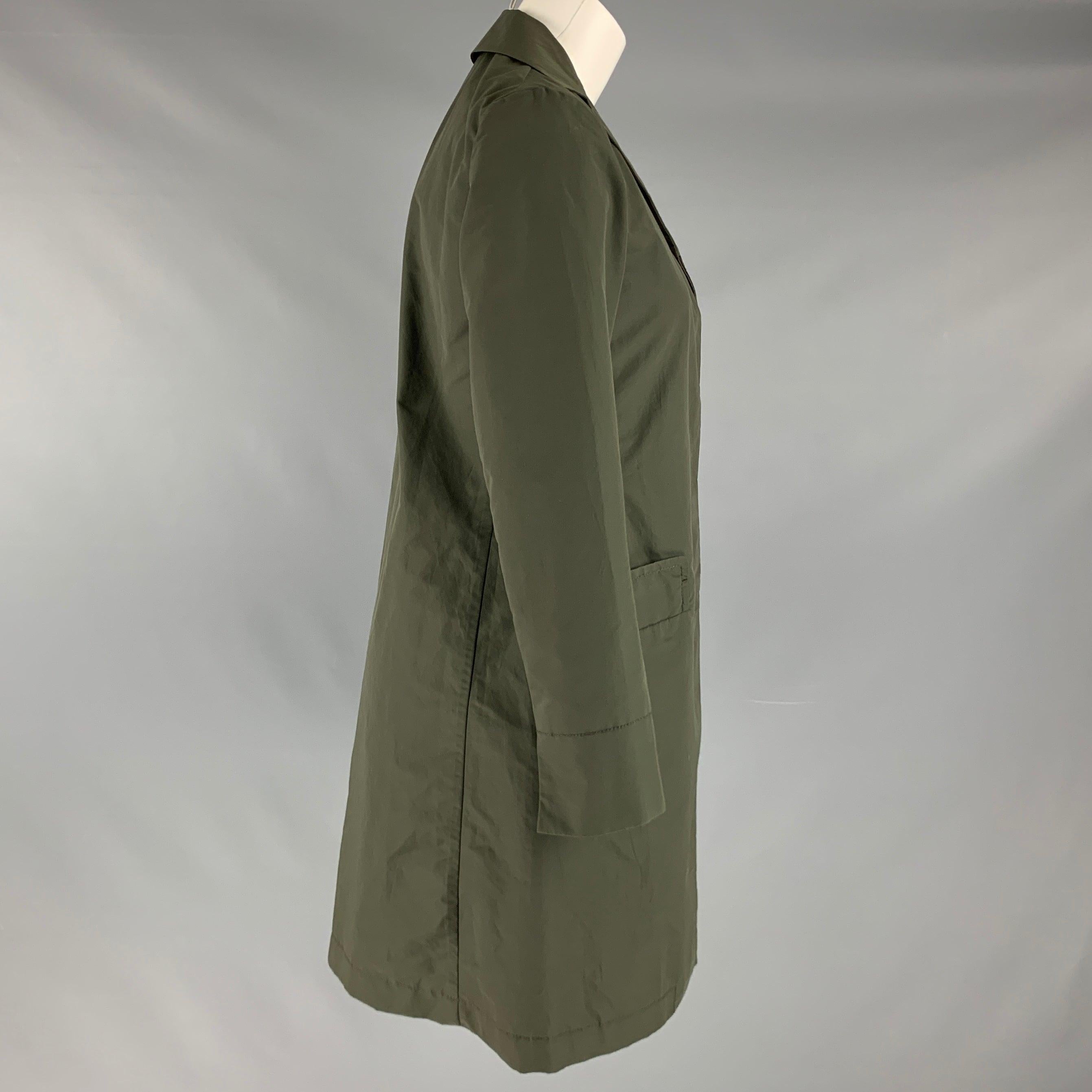 JIL SANDER coat comes in a olive green cotton and polyamide woven featuring a notch lapel, patch pockets, hidden packet, and a three button closure. Made in Italy. Very Good Pre-Owned Condition. 

Marked:   2 

Measurements: 
 
Shoulder: 14.5 inches