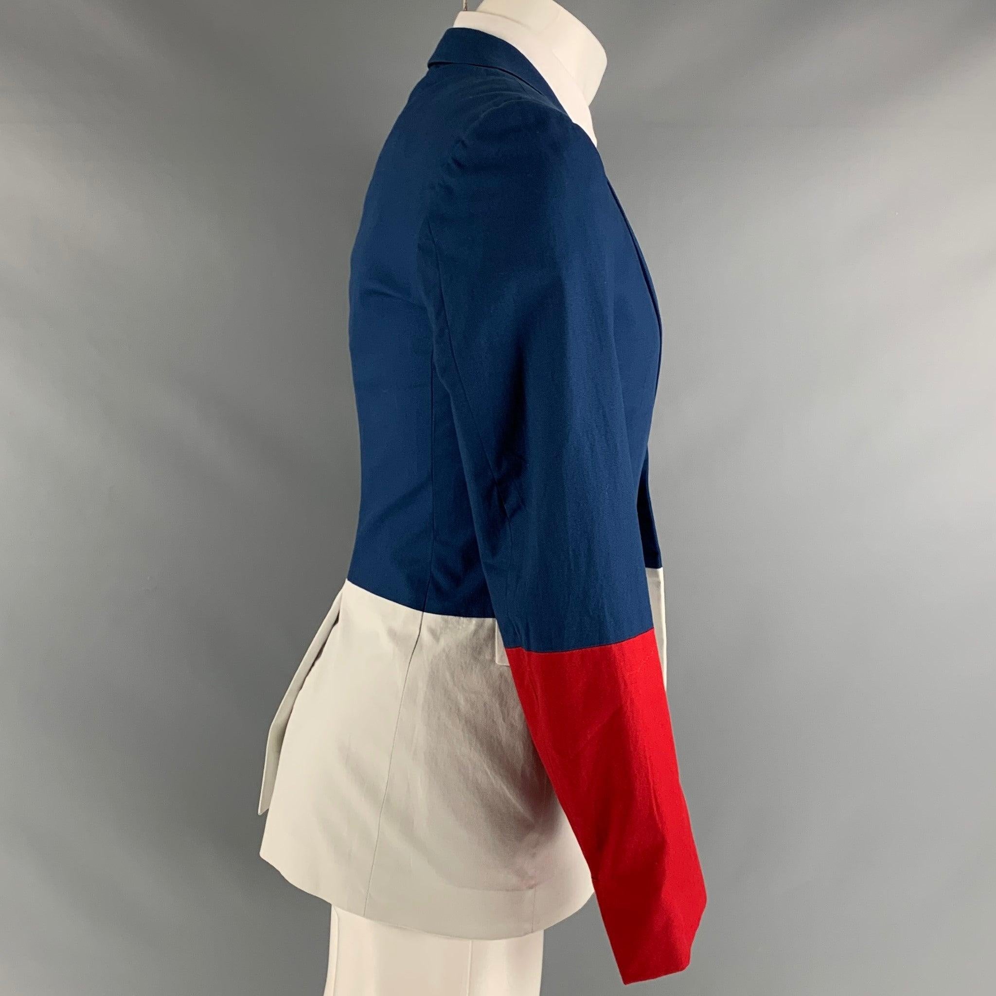 Le manteau de sport JIL SANDER Tailor Made se compose d'un tissu de coton bleu, rouge et blanc, d'une doublure complète, d'un motif color block, d'un revers échancré, de poches à rabat et d'une fermeture à bouton unique. Fabriqué en Italie.