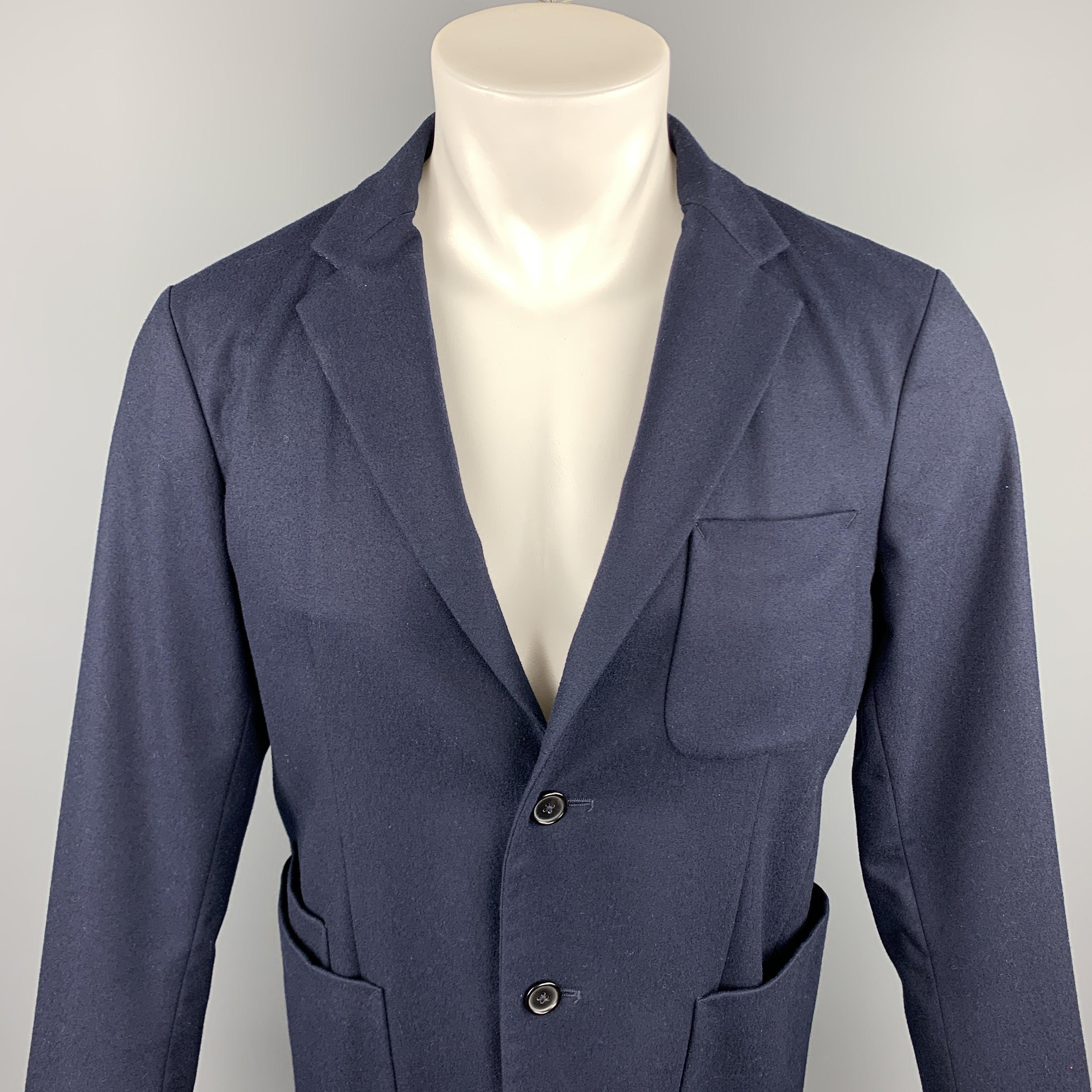 Le manteau de sport JIL SANDER est en laine marine avec un dos en néoprène noir. Il présente un revers à cran, des poches plaquées et une fermeture à deux boutons. Fabriqué en Italie.
Etat d'occasion. 

Marqué :   IT 48 

Mesures : 
 
Épaule : 17.5