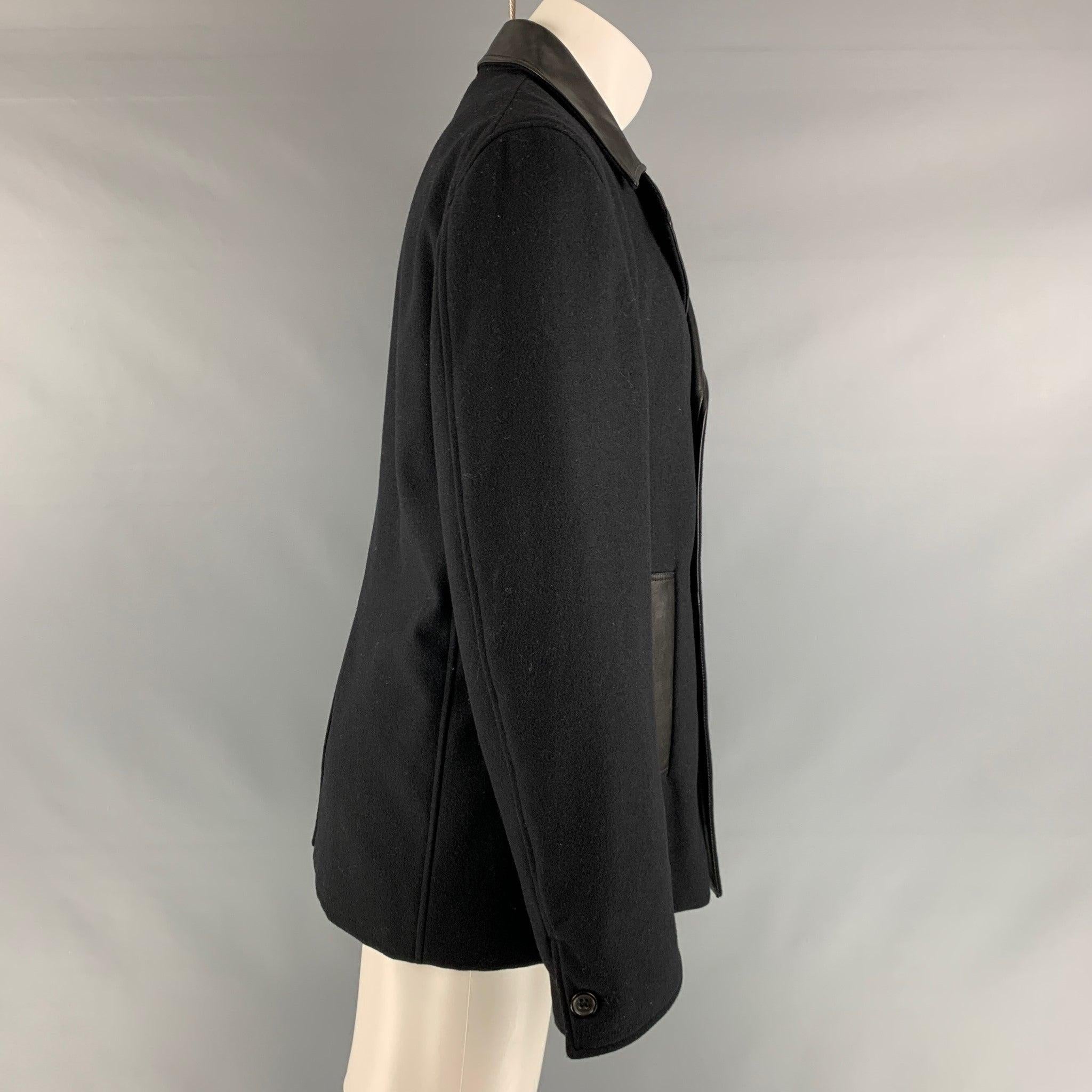 JIL SANDER coat comes in a black wool woven material with a full liner featuring a, black leather details, notch lapel, welt pockets, double breasted, and a button closure.Very Good Pre-Owned Condition. Minor signs of wear. 

Marked:  40