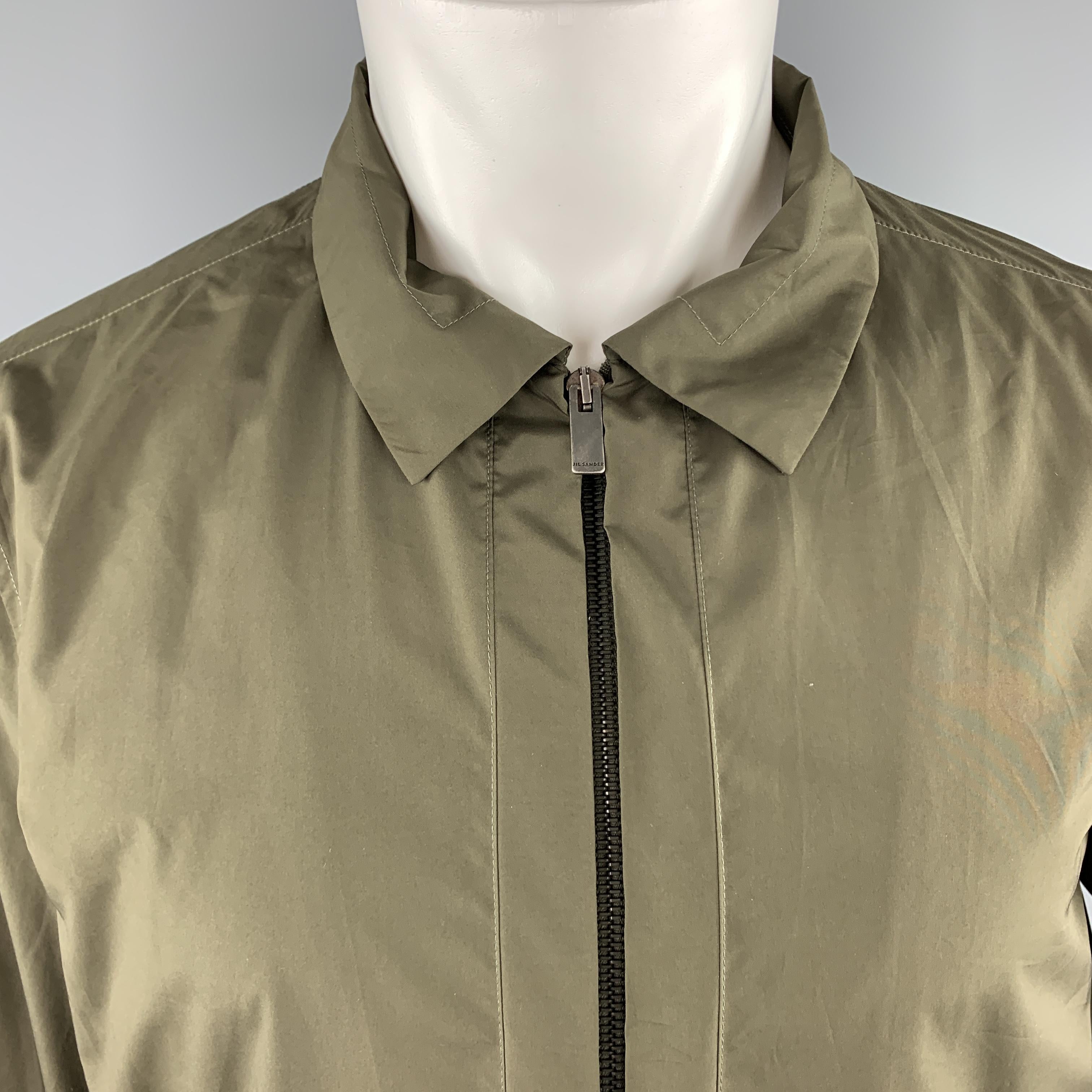 JIL SANDER blouson style jacket comes in olive green windbreaker material with a pointed collar, zip front with open placket, slit pockets, and side tabs. Made in Italy.

Excellent Pre-Owned Condition.
Marked: IT 50

Measurements:

Shoulder: 17