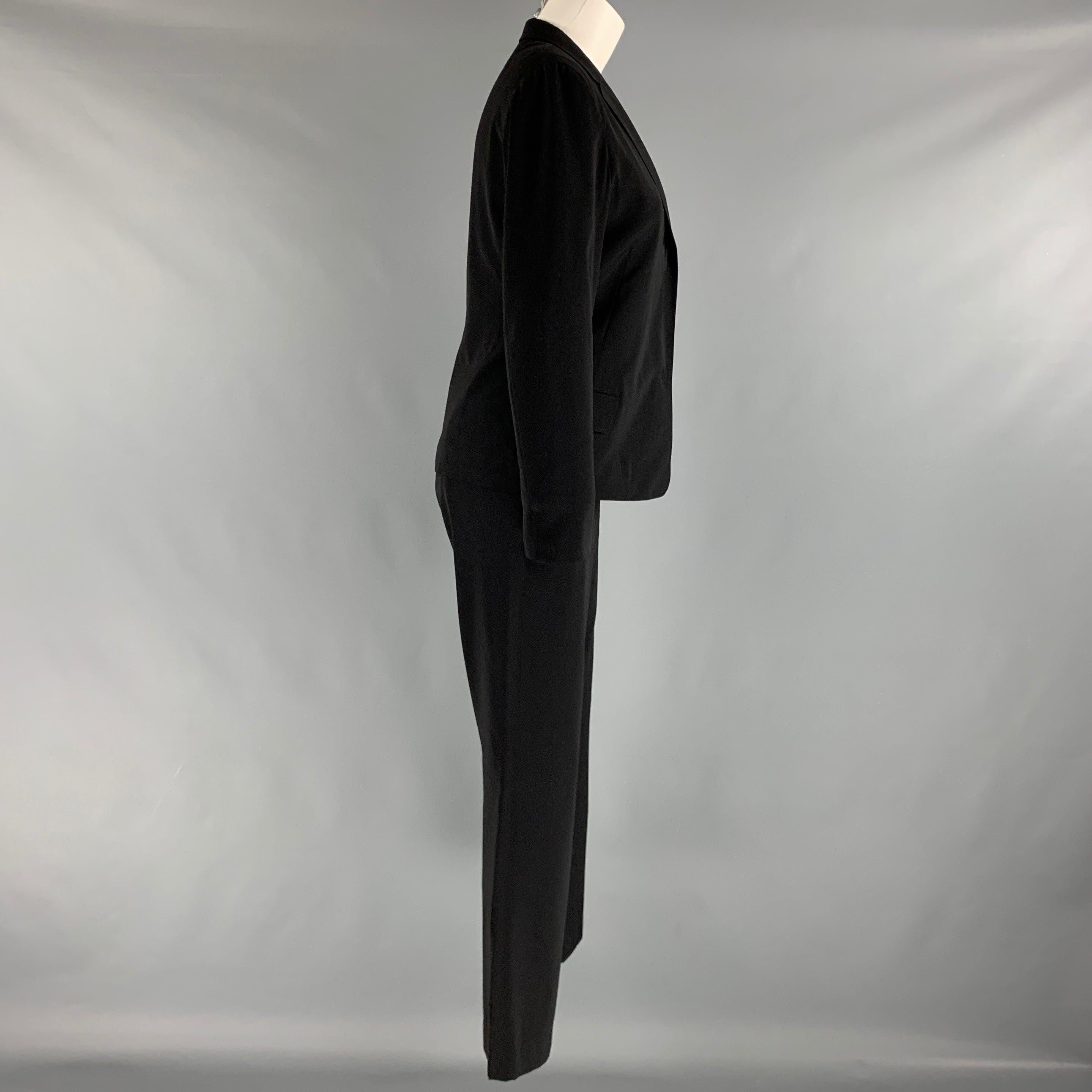 JIL SANDER tailor made pants suit comes in a black silk woven material includes a single button, notch lapel jacket with patch and flap pockets and matching flat front high waist trousers.
 Made in Italy.Excellent Pre-Owned Condition. 

Marked:   36