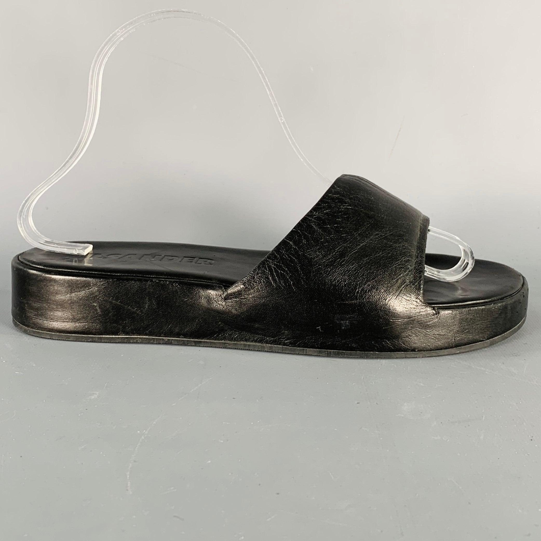 JIL SANDER sandals
in a black leather featuring a platform style and slip on closure. Made in Spainches Very Good Pre-Owned Condition. Moderate signs of wear. 

Marked:   7000 78749 39.5Outsole: 12 inches  x 5 inches 
  
  
 
Sui Generis Reference: