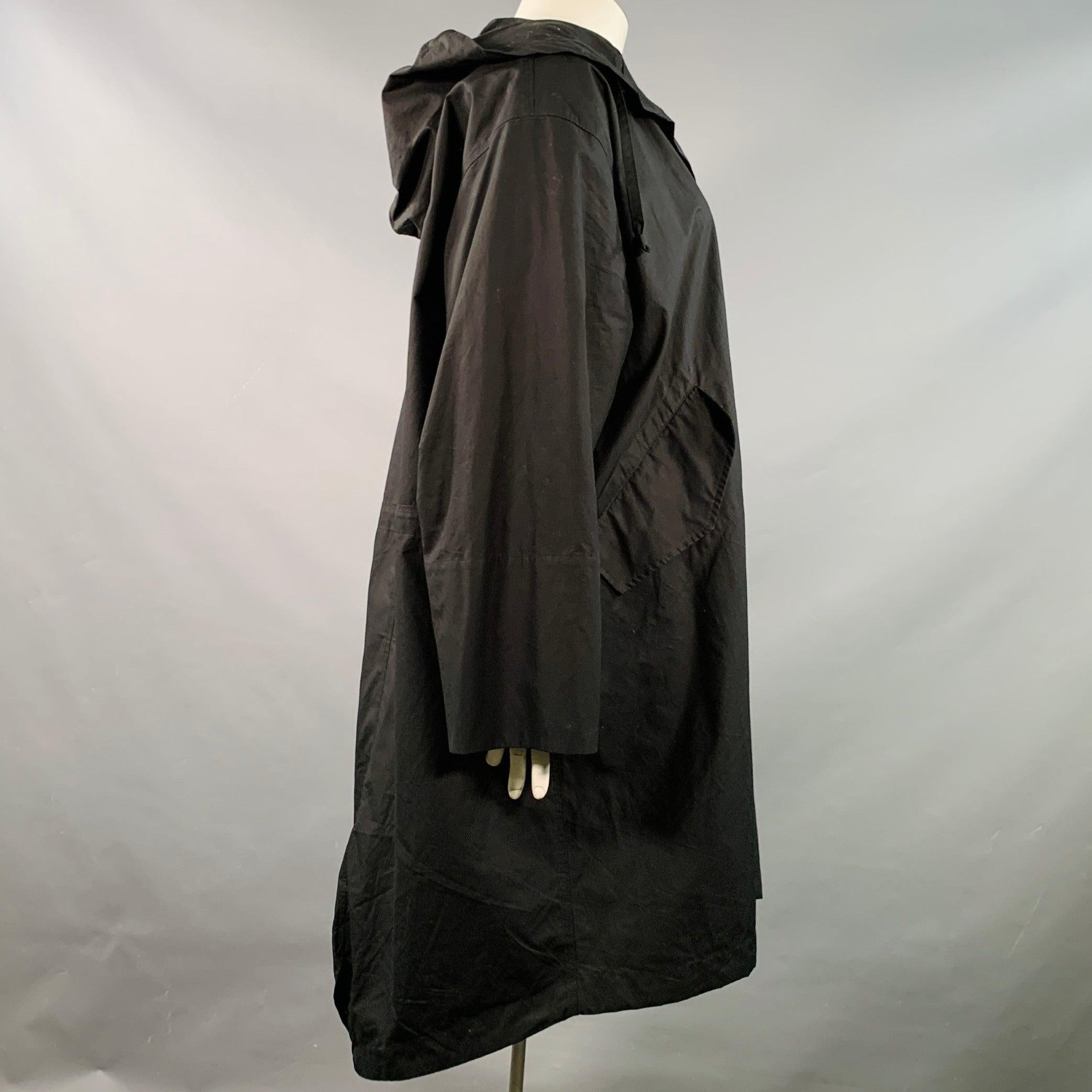Manteau JIL SANDER en coton noir avec capuche, logo blanc au dos et fermeture à bouton-pression. Fabriqué en Italie. Très bon état. Petite marque au recto. 

Marqué :   DE 40  

Mesures : 
 
Epaule : 21 pouces Poitrine : 54 pouces Manche : 23 pouces