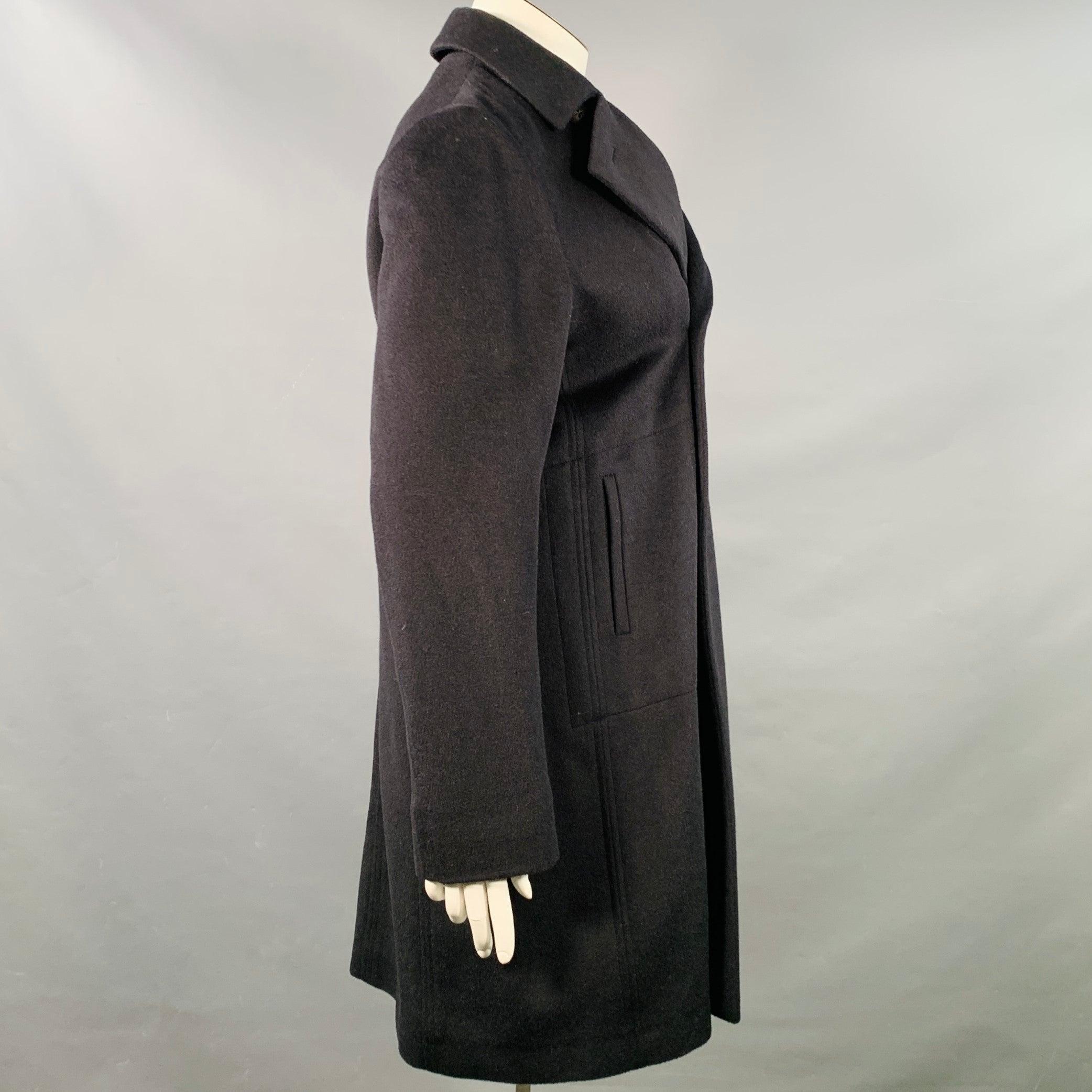 Manteau JIL SANDER
en laine vierge noire mélangée à du camel, avec un double boutonnage, deux poches à glissière et une fermeture à boutons. Excellent état d'origine. 

Marqué :   DE 44 

Mesures : 
 
Épaule : 16.75 pouces Poitrine : 42 pouces