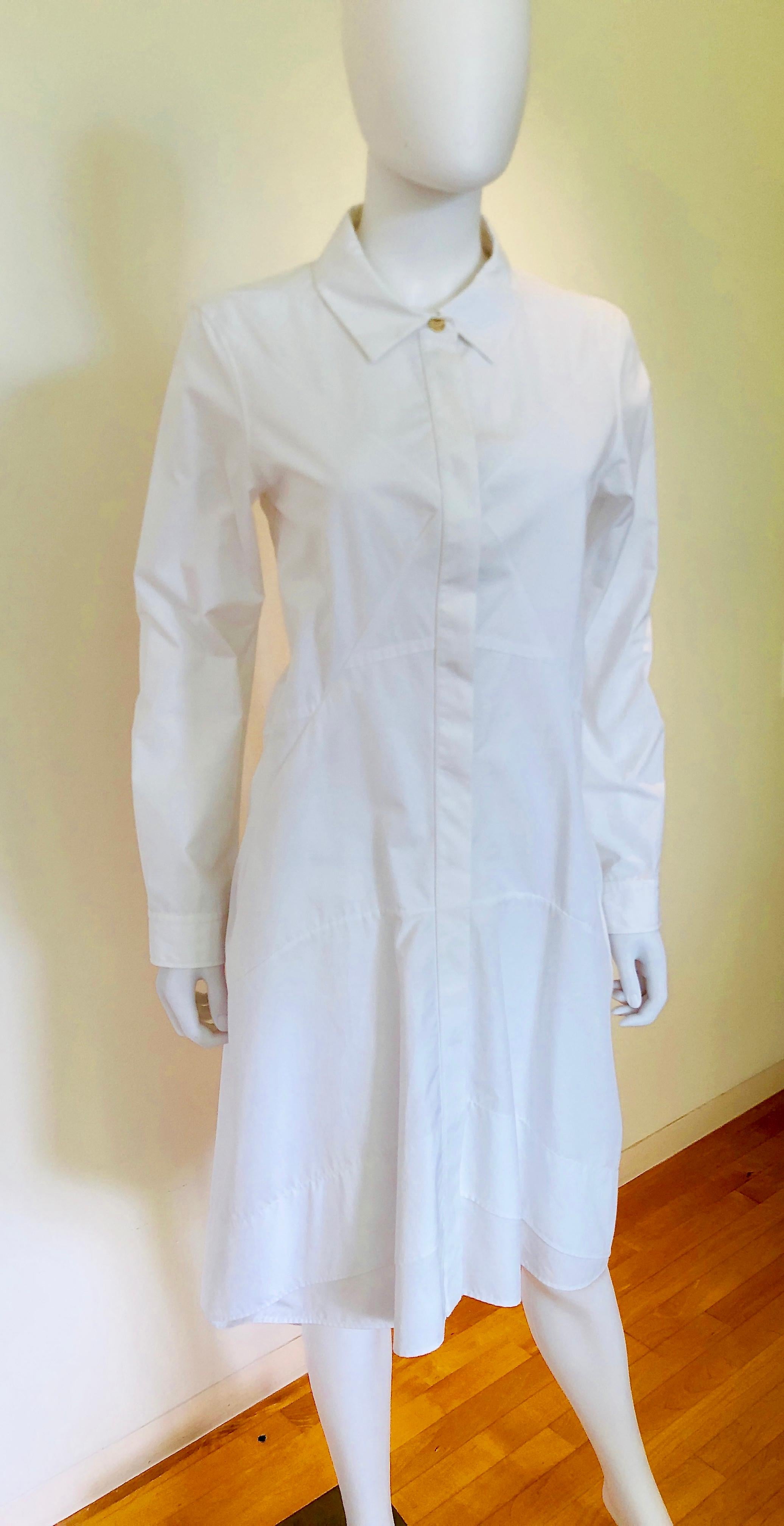 Offered is a Jil Sander size 40 white cotton fitted bodice flared skirt long sleeve button down handkerchief casual day dress.  
Jil Sander
White cotton / fitted bodice / flared skirt / long sleeve / button down / handkerchief hem 
   below the