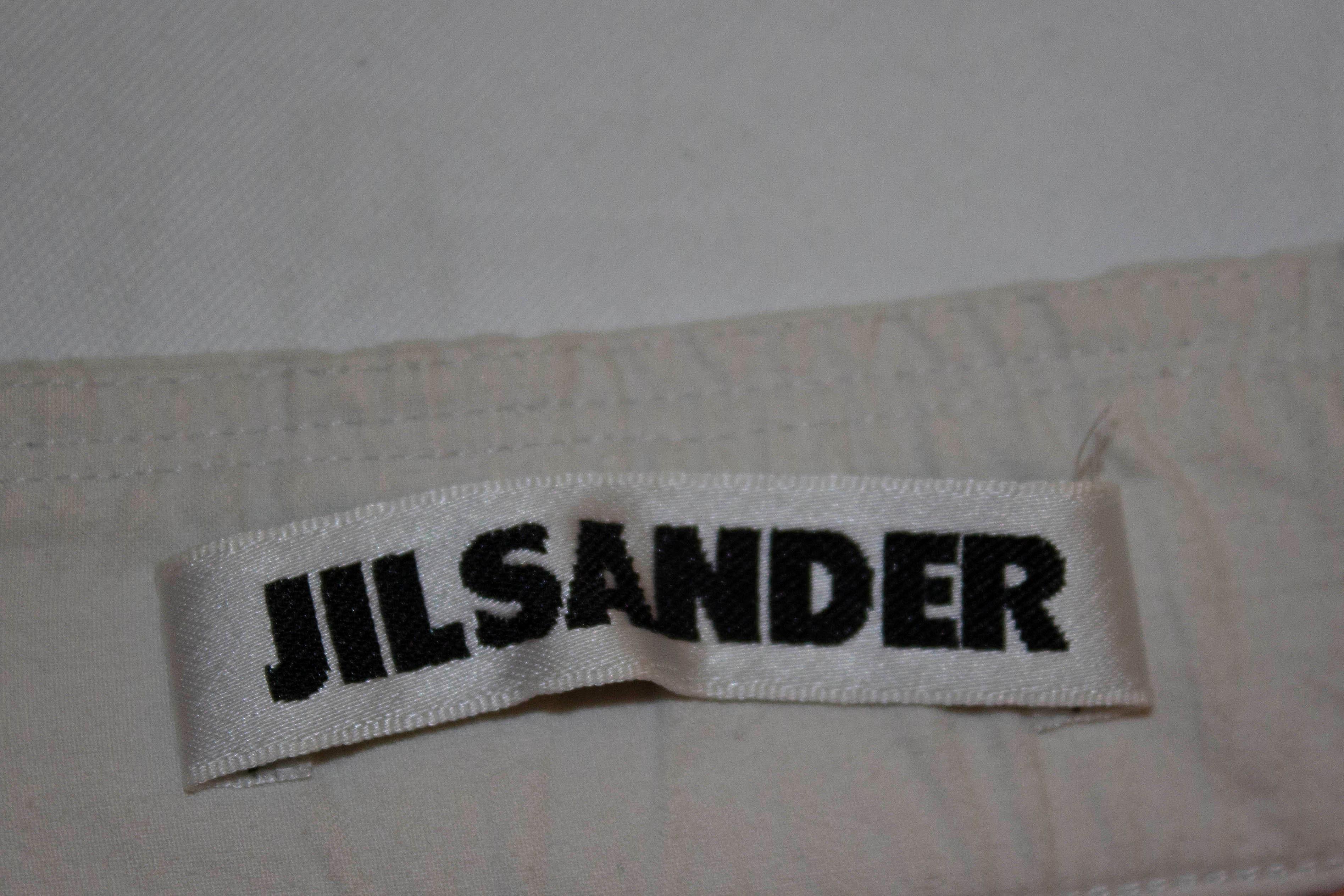 A Spring / Summer classic by Jil Sander. The white cotton trousers, have elastic at the back, belt hoops and a back patch pocket.  Made in Italy
Size 36 waist 29'', inside leg 32''