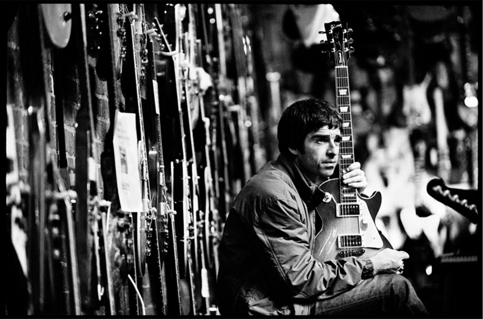 Signed limited edition fine art photograph of Noel Gallagher during his Oasis days by celebrated rock photographer, Jill Furmanovsky.

Location: Music Ground guitar shop, Leeds England
Date: October 2001

Jill Furmanovky recalls 'Guitarists often