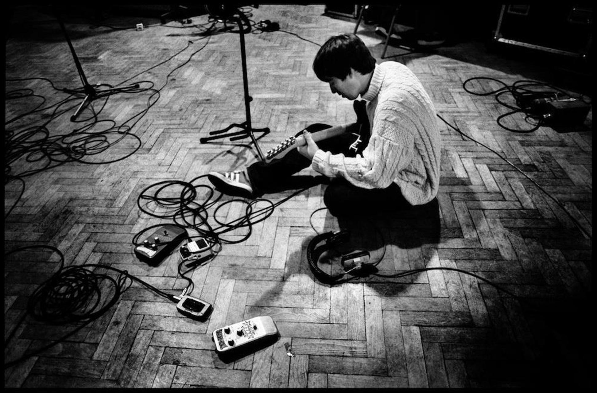Limitierter Kunstdruck von Noel Gallagher von Oasis, der während der Aufnahmen zu Be Here Now im Oktober 1996 seine Gitarre auf dem Boden des Studio Two in den Abbey Road Studios stimmt. Aufgenommen von der Fotografin Jill Furmanovsky.

Signiert und