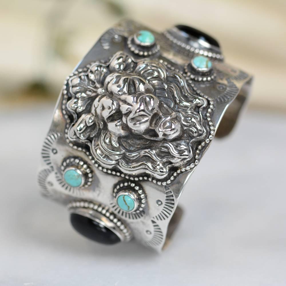 This one of a kind Sterling Silver cuff bracelet features a bold antique late nineteenth century English Art Nouveau Lion framed in delicate beading. Accenting this wonderful figural piece - on either side is a pair of 6 mm natural Royston turquoise