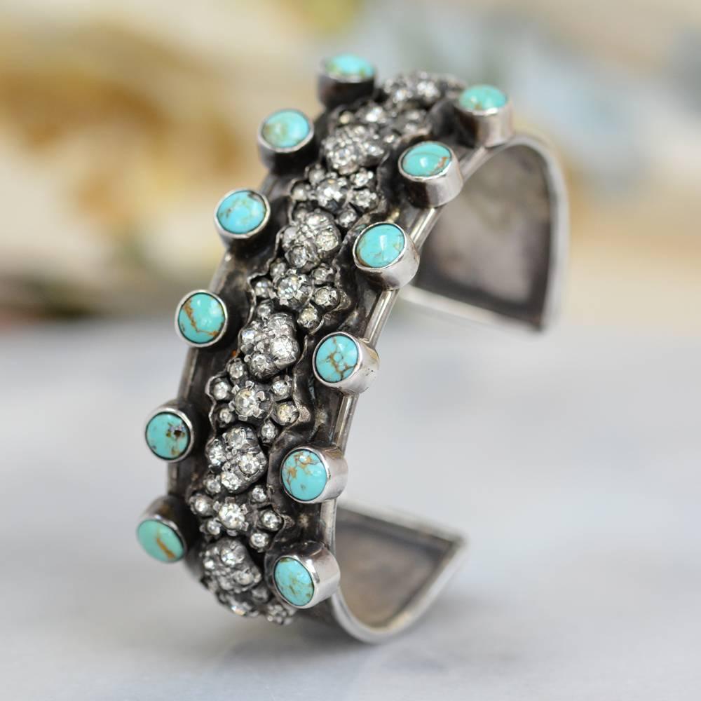 This one of a kind Sterling Silver cuff bracelet features antique nineteenth century French paste fleurette's in a row meticulously framed on either side with six 6 mm natural Royston turquoise cabochons. Each slightly high dome turquoise cabochon