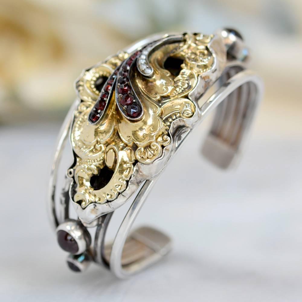 This one of a kind Sterling Silver and Gold cuff bracelet features an antique 14 karat gold Georgian brooch having twenty four original rose cut Bohemian garnets and six natural seed pearls. Accenting this wonderful piece are two 8 mm and two 5 mm