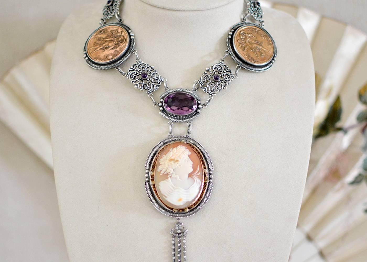 An old cut, 46 carat natural Amethyst set within an elongated oval frame holds a very finely carved mid nineteenth century cameo depicting a Greek Goddess. The original delicate filigree frame of 14 karat gold is mounted within engraved sterling