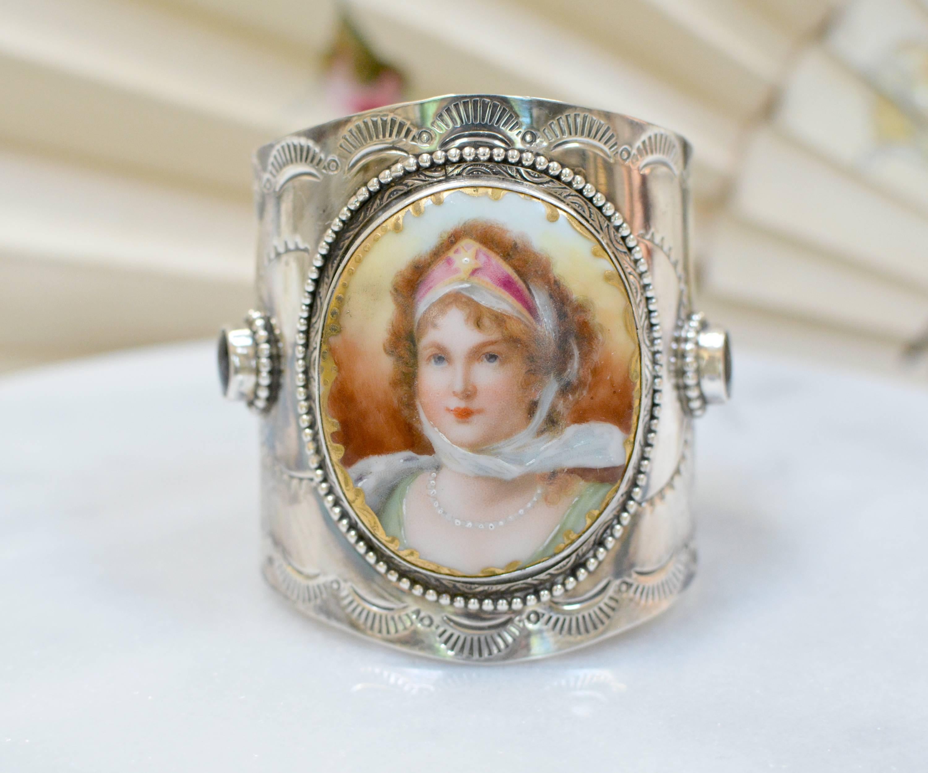 An important one of a kind sterling silver cuff bracelet with a large, French portrait of Queen Louise of Prussia, is framed with engraving and edged in beading. Two deep red 8 x 10 mm oval natural Bohemian garnet cabochons are mounted on either