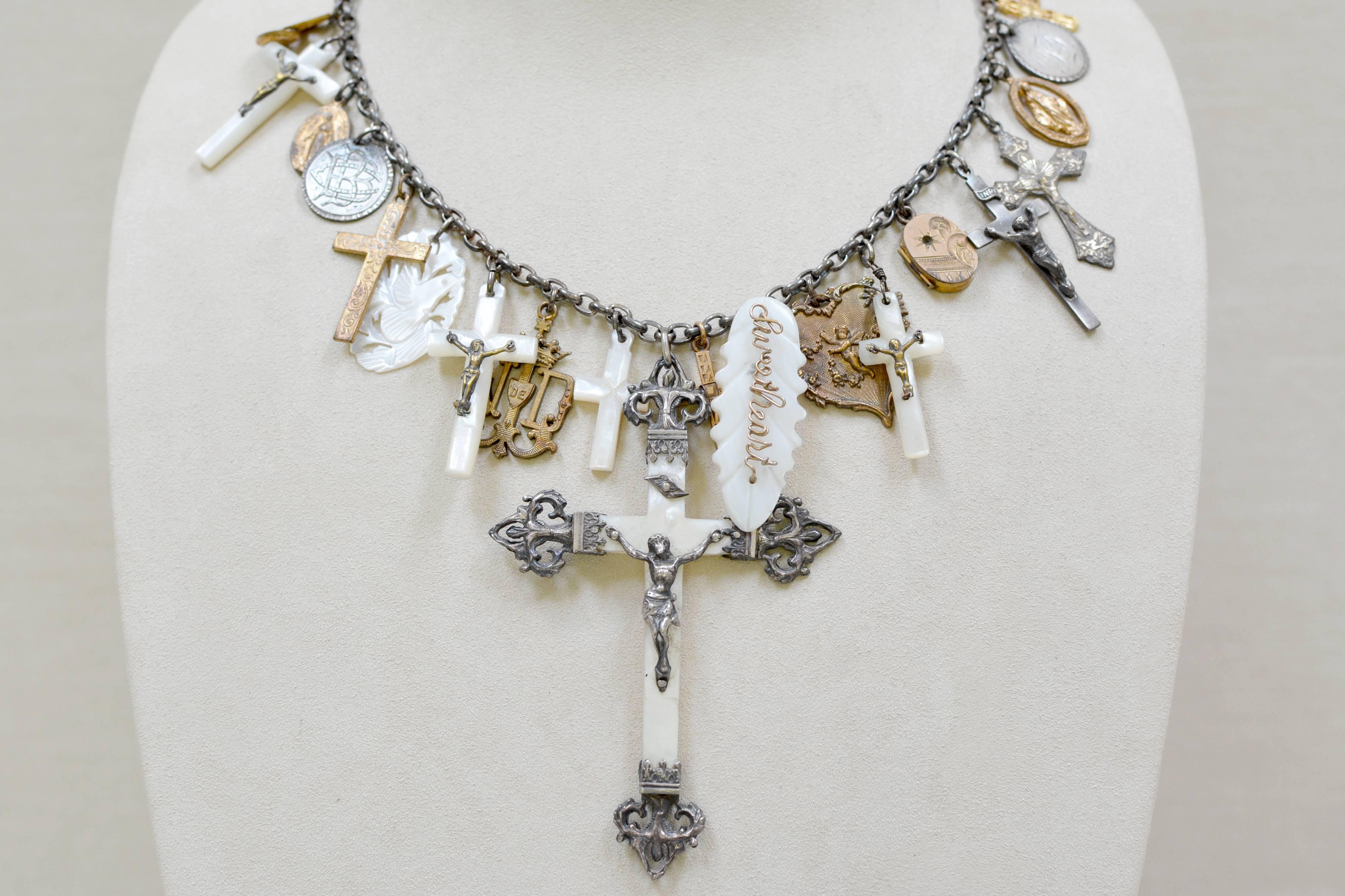 At the center of this one of a kind Love Token Festoon necklace is a grande antique nineteenth century Mother-of-Pearl, sterling filigree French Christening cross. Meticulously curated, iconic treasures abound on a vintage sterling silver chain.