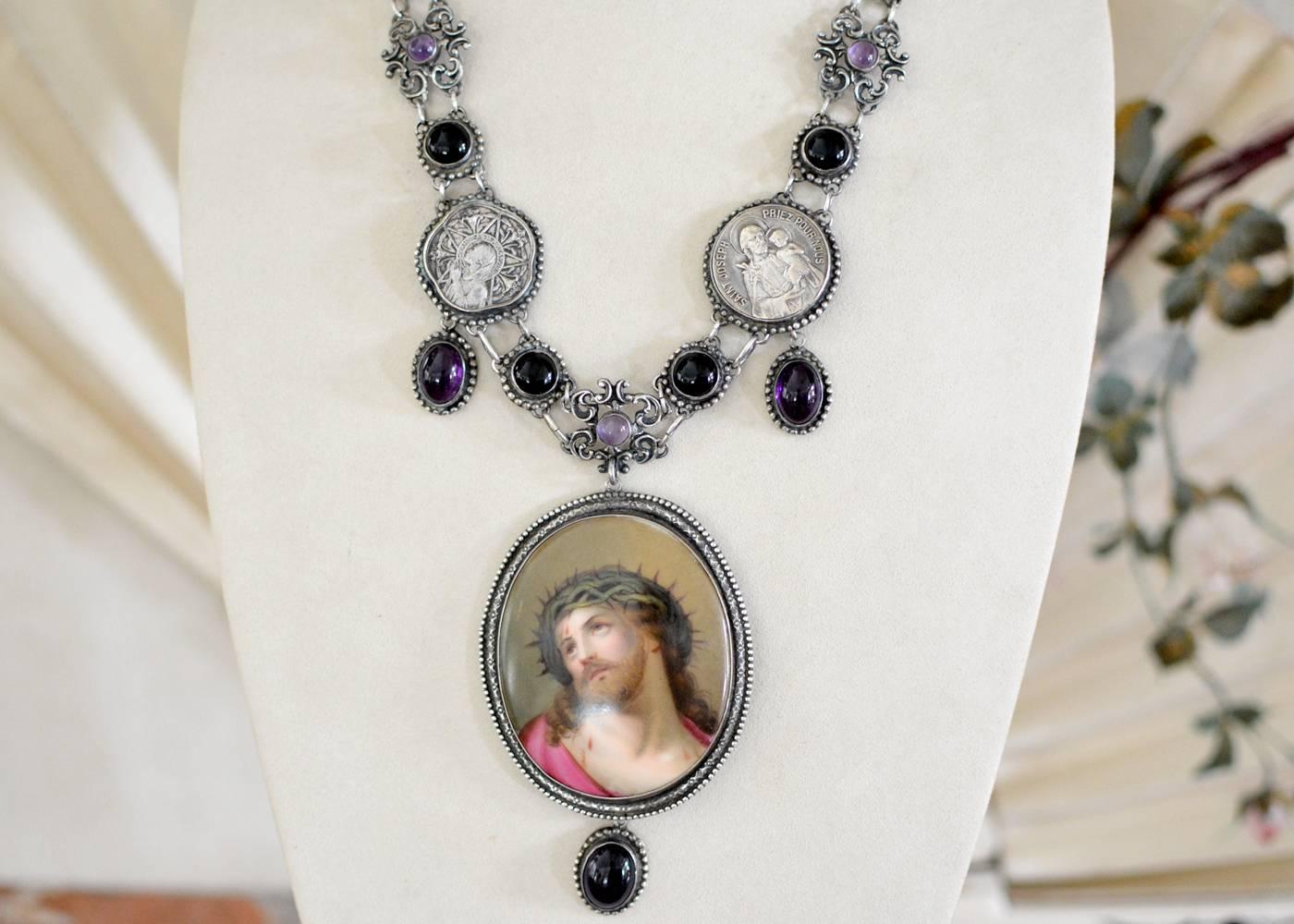 An early nineteenth century sacred French porcelain with an exquisite depiction of Jesus creates the important focal element of this one of a kind necklace. The elaborate collar like chaining combines additional antique nineteenth century elements