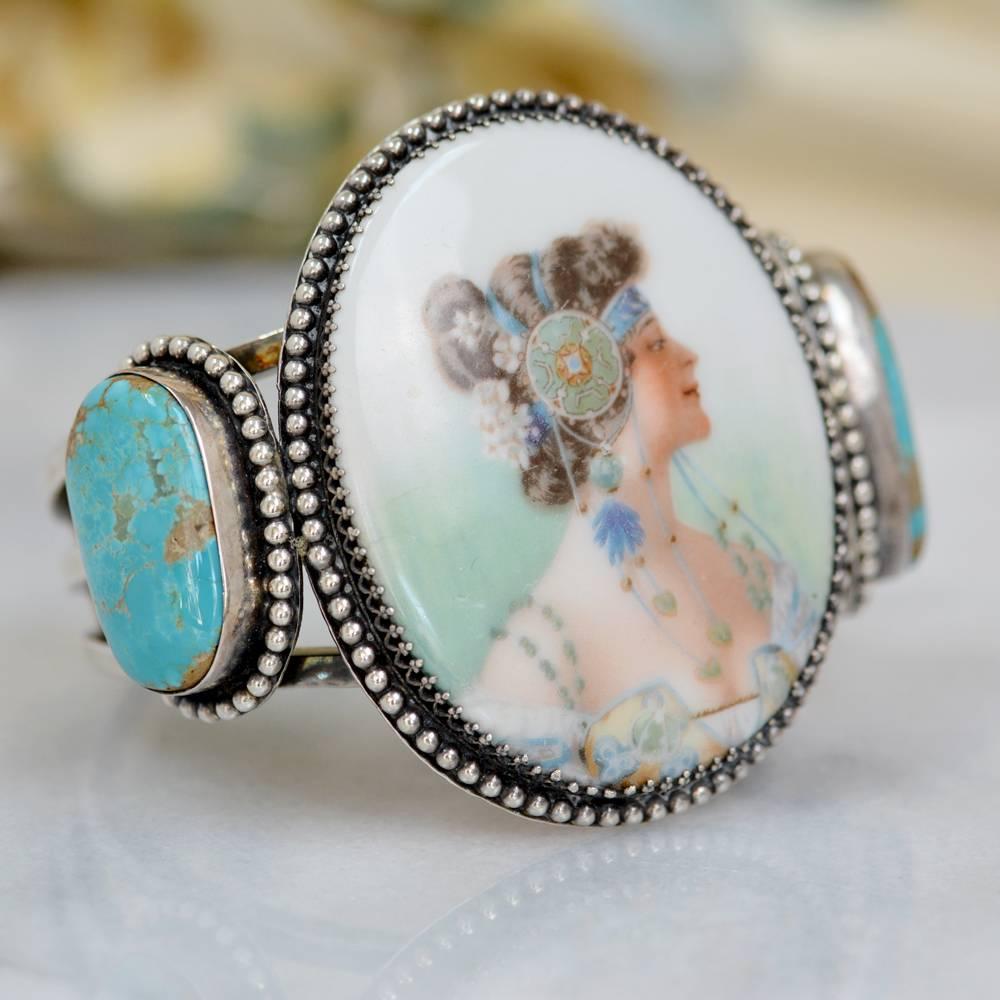 This one of a kind Sterling Silver cuff bracelet features an exquisitely hand painted late nineteenth century French porcelain portrait depicting an Alphonse Mucha Style Goddess measuring 2